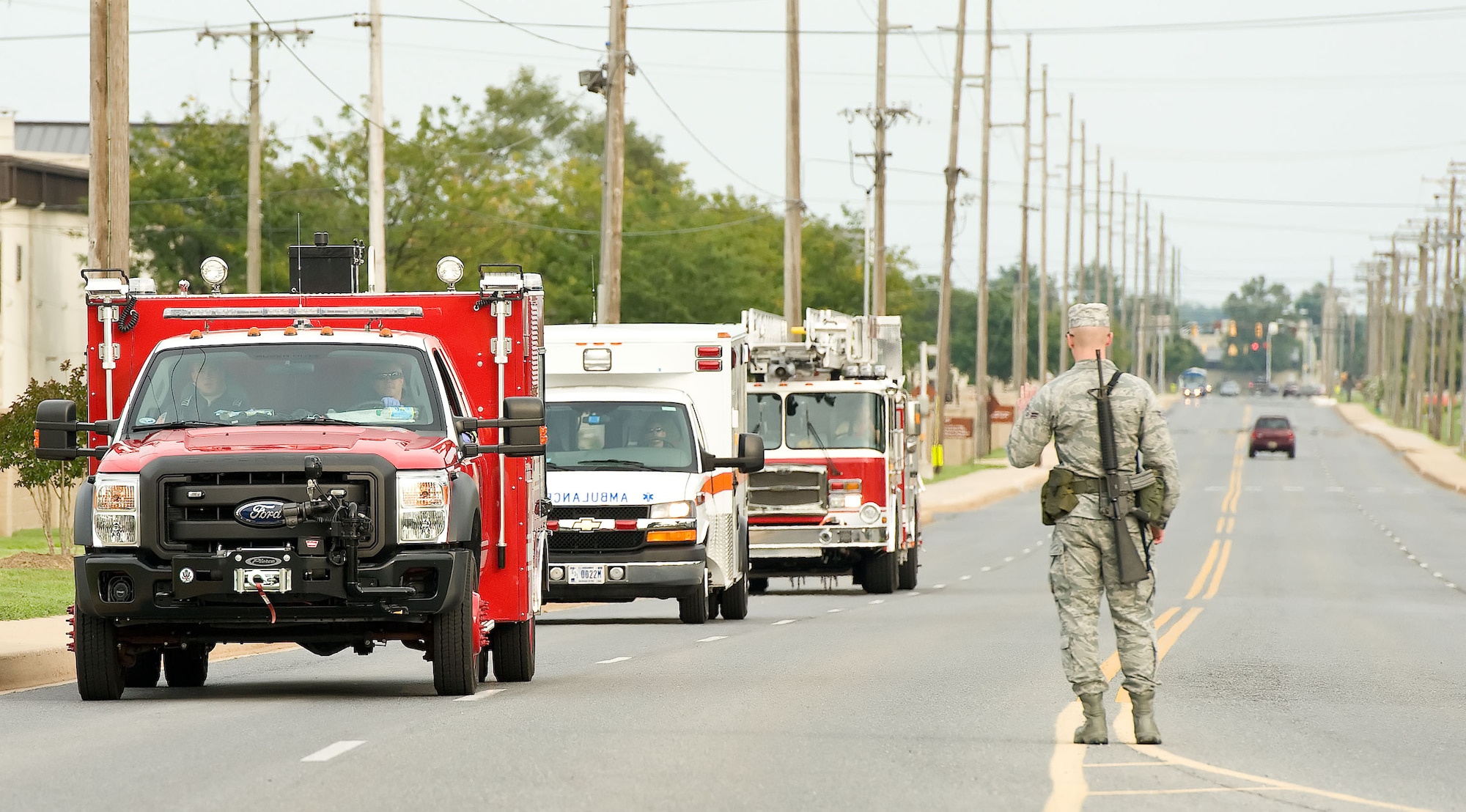 Airman 1st Class Christopher Anderson, an integrated base defense augmentee from the 436th Civil Engineer Squadron, allows emergency vehicles through the entry control point near the North Gate Aug. 20, 2012, at Dover Air Force Base, Del. A simulated single-vehicle incident at the north electrical substation was part of the Aug. 20-22 Major Accident Response Exercise, held to test Team Dover's ability to respond to threats and emergencies. Dover AFB partnered with members of the local community during the MARE to strengthen cooperation and communication between emergency agencies. (U.S. Air Force photo by Roland Balik)