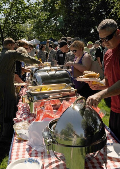 Team Fairchild members get food during the base picnic in Miller Park at Fairchild Air Force Base, Wash., Aug. 17, 2012. The picnic was host to a variety of events including bouncing castles, a rappelling wall, a shirt painting booth, the Air Mobility Command Icon competition, free food and many other booths and activities. (U.S. Air Force photo by Staff Sgt. Michael Means)
