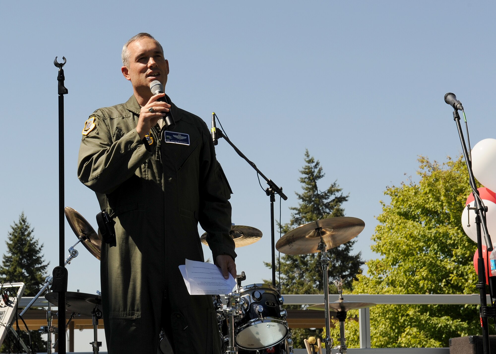 Col. Brian Newberry, 92nd Air Refueling Wing commander, speaks to Team Fairchild during the base picnic in Miller Park at Fairchild Air Force Base, Wash., Aug. 17, 2012. The picnic was host to a variety of events including bouncing castles, a rappelling wall, a shirt painting booth, the Air Mobility Icon competition, free food and many other booths and activities. (U.S. Air Force photo by Staff Sgt. Michael Means)