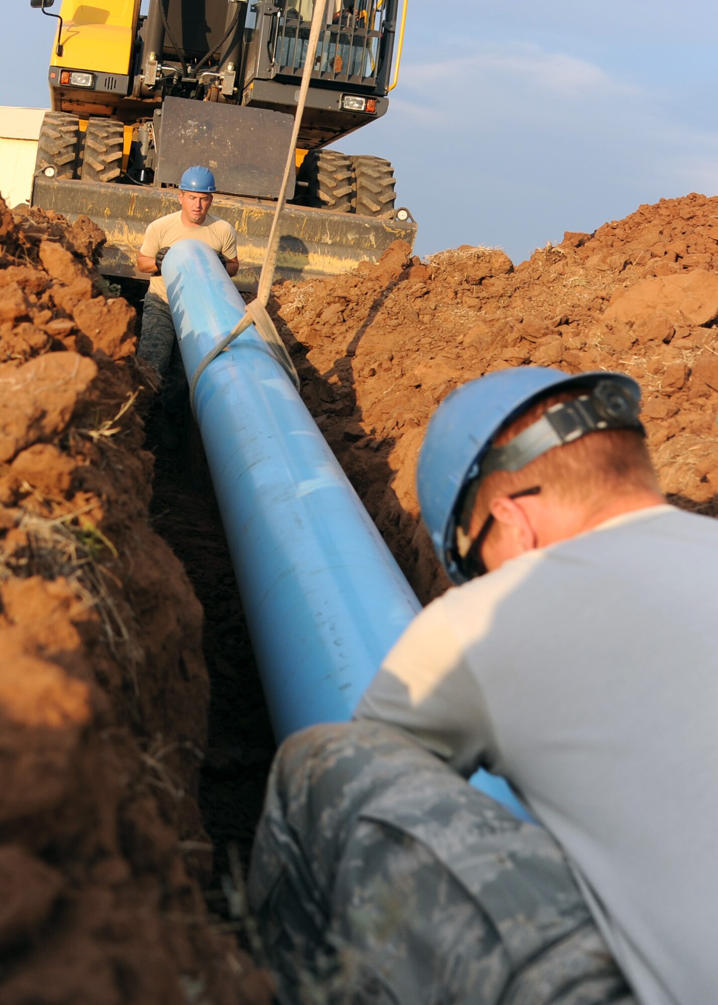 ALTUS AIR FORCE BASE, Okla. –Senior Airman Corey Barr, 97th Civil Engineer Squadron water and fuel systems maintenance journeyman, and Airman 1st Class Michael Wiggins, 97th CES water and fuel systems maintenance apprentice, install a pipe behind a tanker fuel yard, Aug. 14, 2012. The 97th CES is working on a raw water irrigation project which satisfies a cost-conscious culture. The non-potable irrigation water will be used to water the Windy Trails Golf Course, saving the base around $48,000 on utility cost per year and saving the City of Altus around $12,000 on operational cost per year. (U.S. Air Force photo by Airman 1st Class Klynne Pearl Serrano / 97th Air Mobility Wing / Released)