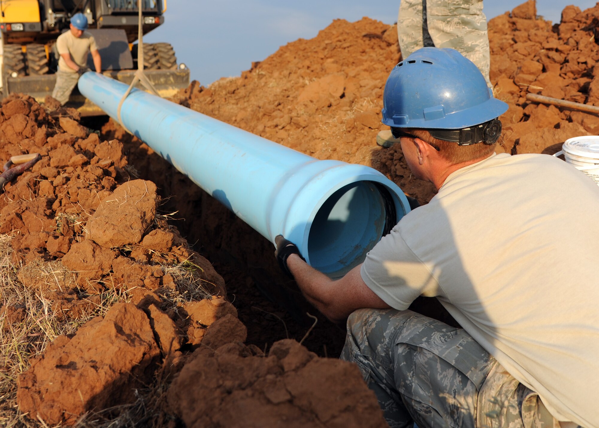 ALTUS AIR FORCE BASE, Okla. –Senior Airman Corey Barr, 97th Civil Engineer Squadron water and fuel systems maintenance journeyman, and Airman 1st Class Michael Wiggins, 97th CES water and fuel systems maintenance apprentice, install a pipe behind a tanker fuel yard, Aug. 14, 2012. The 97th CES is working on a raw water irrigation project which satisfies a cost-conscious culture. The non-potable irrigation water will be used to water the Windy Trails Golf Course, saving the base around $48,000 on utility cost per year and saving the City of Altus around $12,000 on operational cost per year. (U.S. Air Force photo by Airman 1st Class Klynne Pearl Serrano / 97th Air Mobility Wing / Released)