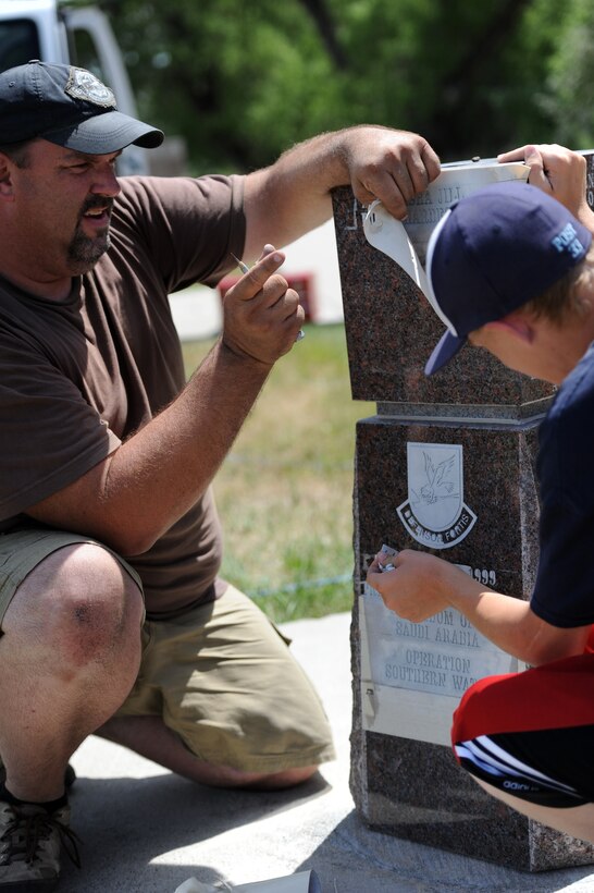 Mark and Caleb Luken, West River Monument Company monument engravers, prepare to review their work on a memorial at Memorial Park in memory of Airman 1st Class Leasha Jill Bjork-Hardesty at Ellsworth Air Force Base, S.D., July 19, 2012. Bjork-Hardesty was killed in a vehicle accident Nov. 16, 1999, during Operation Southern Watch at Prince Sultan Air Base, Kingdom of Saudi Arabia. (U.S. Air Force photo by Airman 1st Class Hrair H. Palyan/Released)