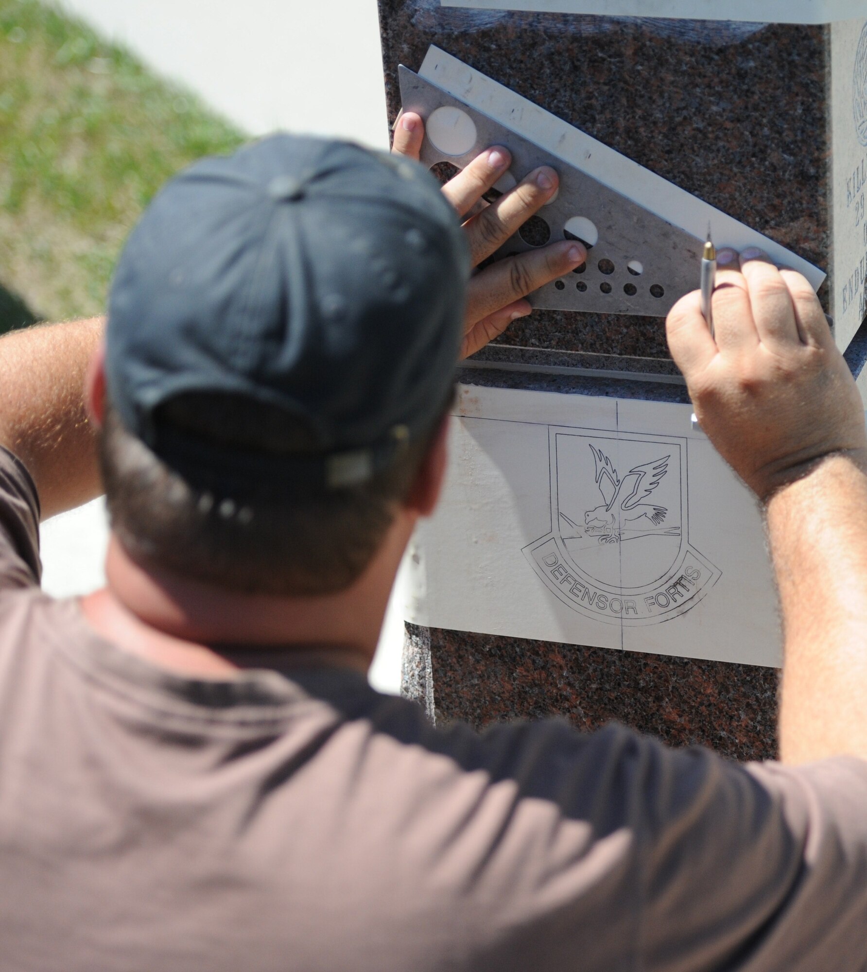 Mark Luken, West River Monument Company monument engraver, carves out letters from a rubberized stencil in the process of engraving a memorial at Memorial Park in tribute to Airman 1st Class Leasha Jill Bjork-Hardesty at Ellsworth Air Force Base, S.D., July 19, 2012. After a rubberized stencil was secured on a monument, engravers used a sandblaster to engrave letters.  (U.S. Air Force photo by Airman 1st Class Hrair H. Palyan/Released)