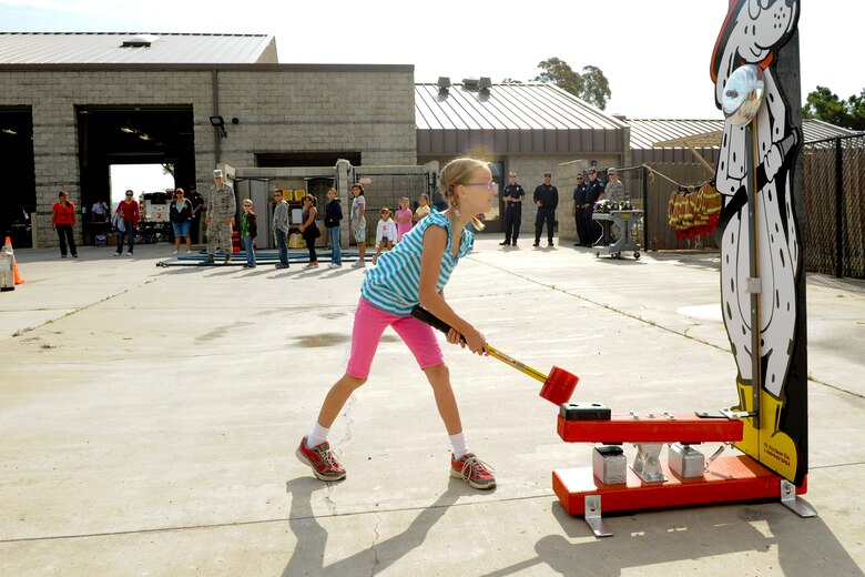 VANDENBERG AIR FORCE BASE, Calif. -- Jaden Zatorski, daughter of Constance and Capt. Benjamin Zatorski, a 532nd Training Squadron instructor, smashes a hammer into a  fire dog themed high striker while running an obstacle course during the 2012 Kids Fire Camp at Fire Station 2 here Saturday, August 18, 2012. The fire camp was held to provide kids on base with fire safety information, hands-on learning and critical home fire safety skills. (U.S. Air Force photo/Staff Sgt. Levi Riendeau)