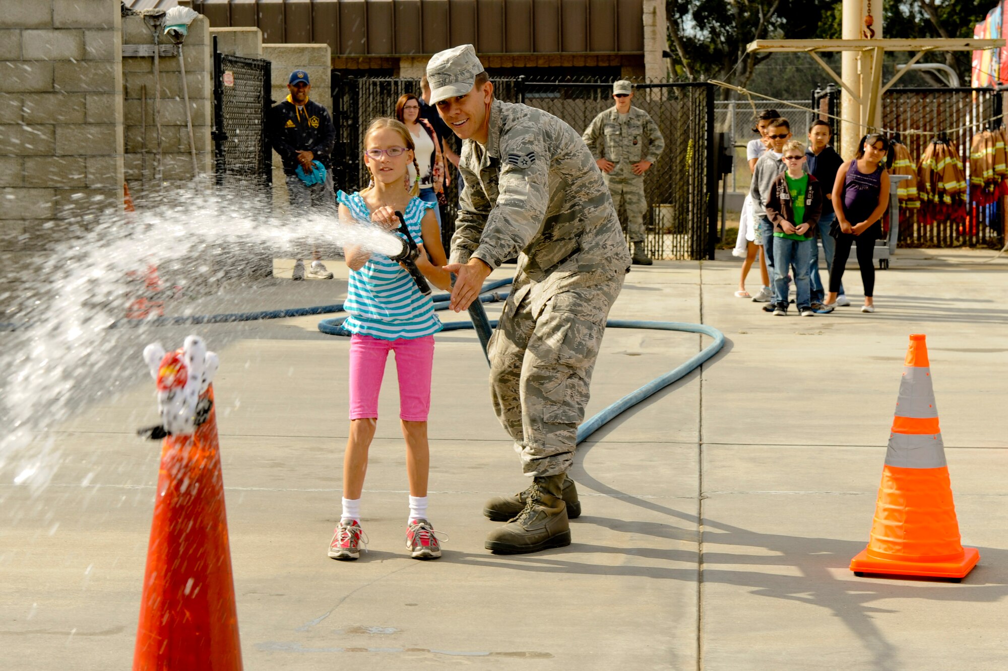 VANDENBERG AIR FORCE BASE, Calif. -- Jaden Zatorski, daughter of Constance and Capt. Benjamin Zatorski, a 532nd Training Squadron instructor, uses a fire hose to knock a stuffed animal from a cone while running an obstacle course during the 2012 Kids Fire Camp at Fire Station 2 here Saturday, August 18, 2012. The fire camp was held to provide kids on base with fire safety information, hands-on learning and critical home fire safety skills. (U.S. Air Force photo/Staff Sgt. Levi Riendeau)