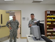 Air Force Maj. John Catoe (right), Medical Education and Training Campus Pharmacy program director, shows Army Col. James Chevallier, 502nd Air Base Wing incoming vice commander, tele-pharmacy equipment and explains how the technology allows a pharmacist to check prescriptions from a geographically separated location. Chevallier visited the facility Aug. 17. (U.S. Navy photo by Dewite Wehrman)