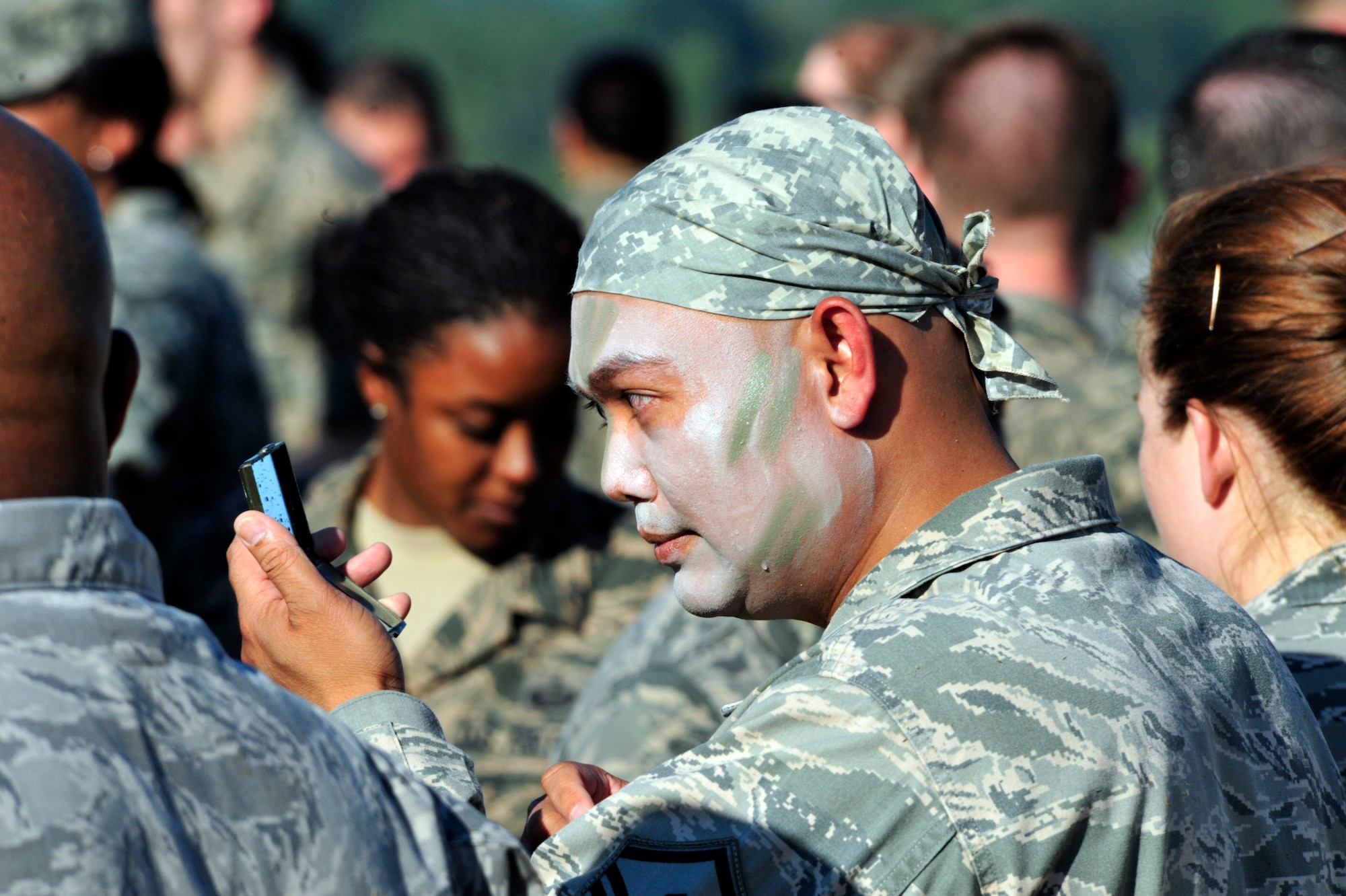 Master Sgt. Henry Davis, 62nd Operations Support Squadron first sergeant, checks his camouflage face paint in order to get ready for simulated battle, Aug. 17, 2012 for the McChord Field Combat Dining-in at Heritage Hill, Joint Base Lewis-McChord, Wash. The dining-in ceremony is a formal military ceremony that fosters camaraderie and espirit de corps within a unit. (U.S. Air Force photo/Master Sgt. Todd Wivell)