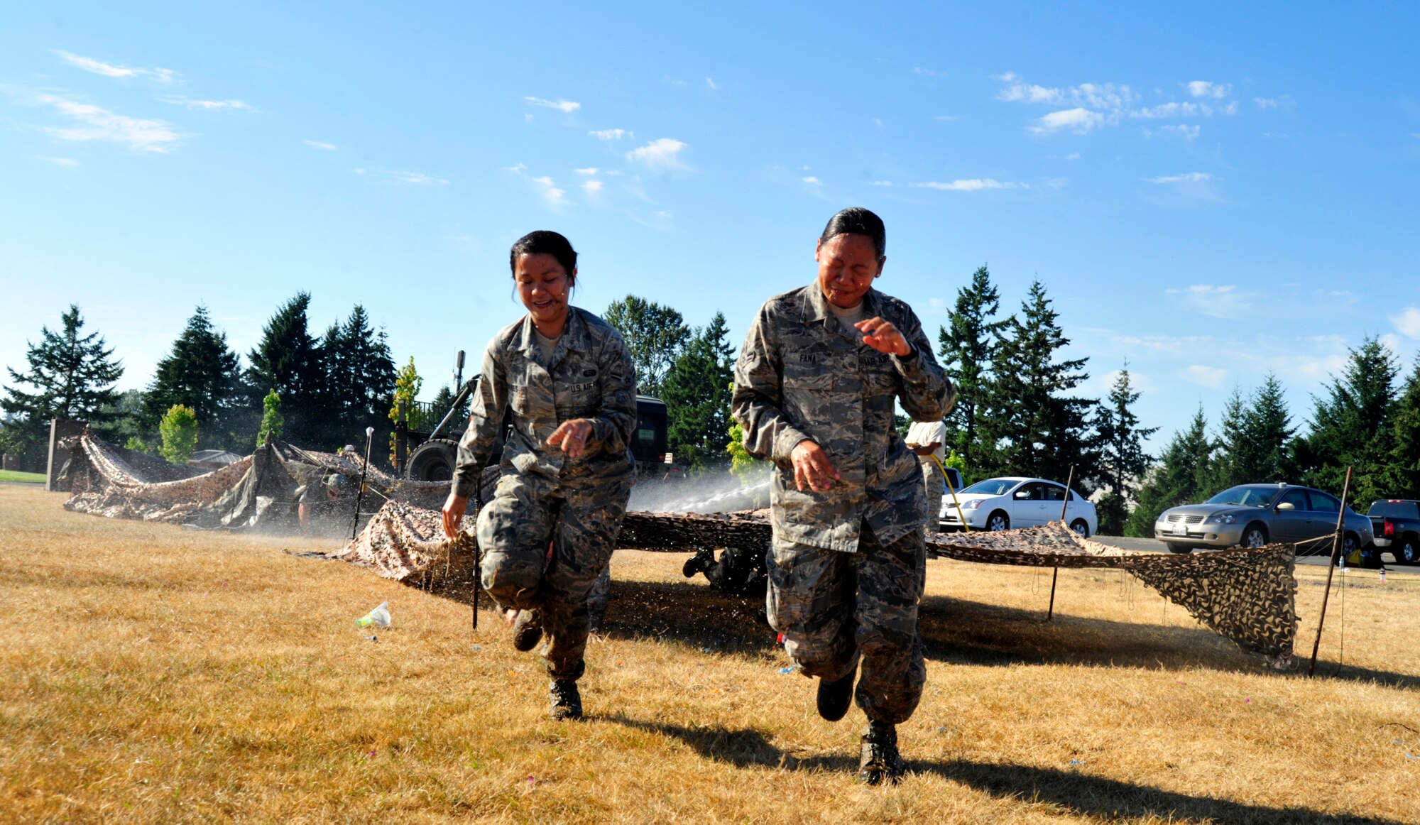 Two Airmen navigate the obstacle course, Aug. 17, 2012 during the McChord Field Combat Dining-in at Heritage Hill, Joint Base Lewis-McChord, Wash. Members had to navigate an obstacle course that included jumping, low-crawling and balancing all while being bombarded with water, before being allowed into the event. (U.S. Air Force photo/Master Sgt. Todd Wivell)