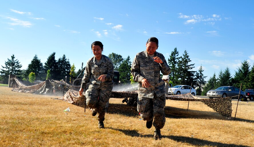 Two Airmen navigate the obstacle course, Aug. 17, 2012 during the McChord Field Combat Dining-in at Heritage Hill, Joint Base Lewis-McChord, Wash. Members had to navigate an obstacle course that included jumping, low-crawling and balancing all while being bombarded with water, before being allowed into the event. (U.S. Air Force photo/Master Sgt. Todd Wivell)