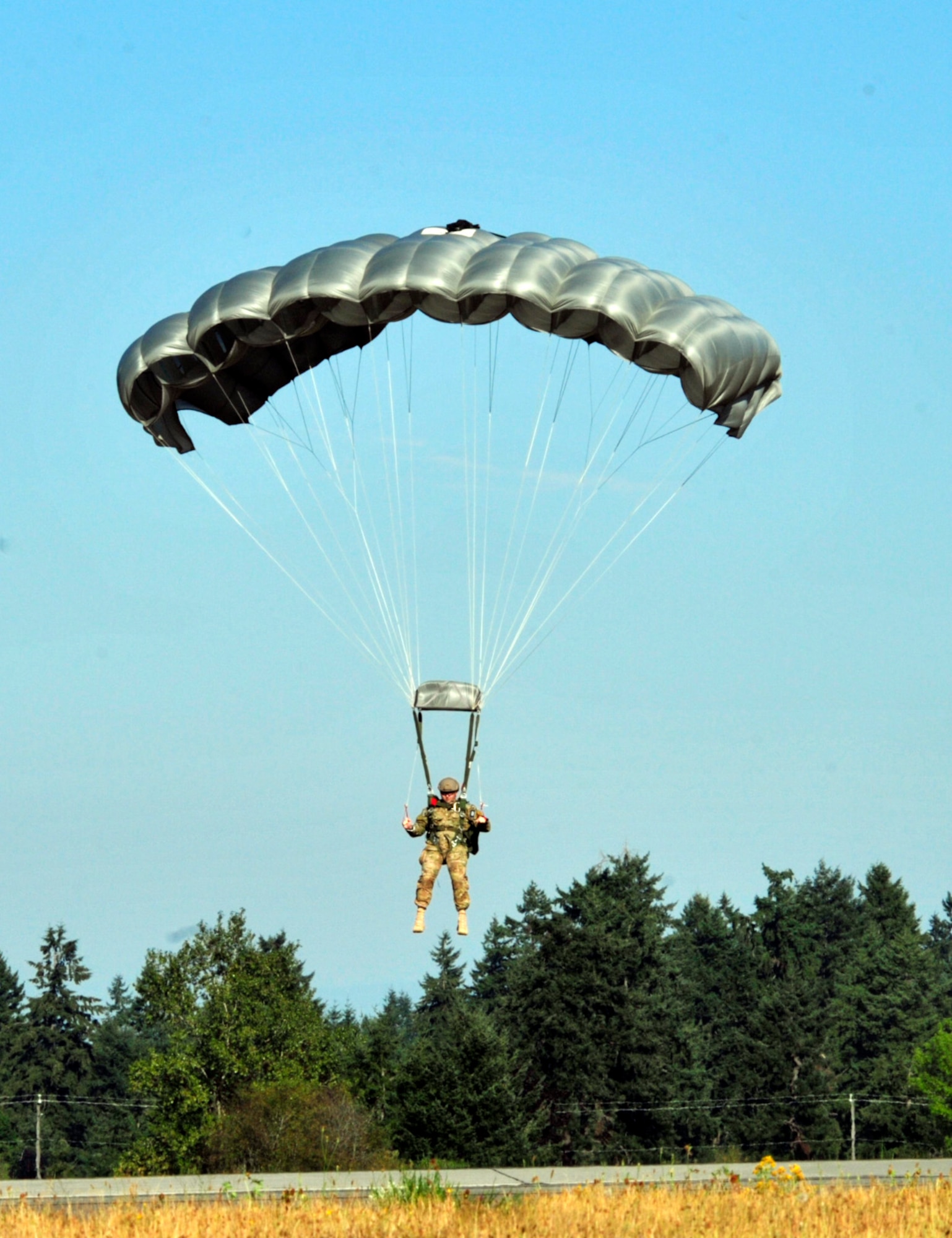 Chief Master Sgt. Bruce Dixon, 24th Special Operations Wing command chief and guest speaker, parachutes in to an open field, Aug. 17, 2012 during the McChord Field Combat Dining-in at Heritage Hill, Joint Base Lewis-McChord, Wash. Dixon spoke of what it really means to be an Airman in today's Air Force. (U.S. Air Force photo/Master Sgt. Todd Wivell)