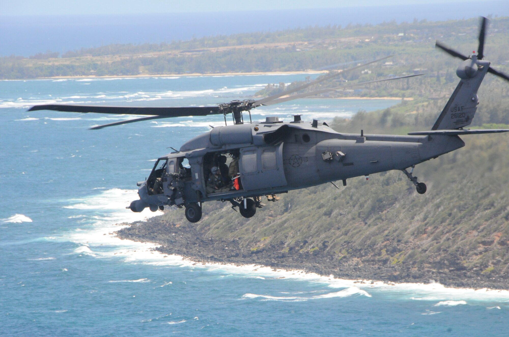 California Air National HH-60G Pave Hawk rescue helicopter from the 129th Rescue Wing, Moffet Field, Calif. conducts a Combat Search and Rescue(CSAR) personnel recovery mission at the Rim of the Pacific exercise in an isolated area on the island of Oahu, Hawaii on July 23, 2012. During the exercise the Pararescue Jumpers (PJs) make contact with the downed aviator, treat his immediate medical needs and transport him back to safety as the 144th Fighter Wing, Fresno, Calif. provide Rescue Combat Air Patrol (RESCAP) with their F-16 fighter jets above in the blue Hawaiian skies. (Air National Guard photo by Master Sgt. David J. Loeffler)