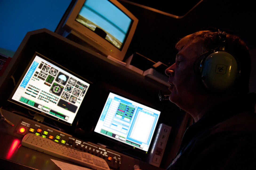Glenn Quarles, 47th Student Squadron simulator instructor, speaks with a student pilot over the radio as he monitors their flight progress from a T-6 simulator control console at Jarvis Hall at Laughlin Air Force Base, Texas, Aug. 20, 2012. Laughlin’s T-6, T-38 and T-1 aircraft simulators help teach would-be pilots the foundation and basic skills necessary for Air Force pilots and help graduate Laughlin’s more than 300 pilot graduates each year. (U.S. Air Force photo/Airman 1st Class Nathan Maysonet)