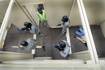 A team of 50th Security Forces Squadron Airmen clears the room during an active-shooter response live scenario training Aug. 20 at the shoot house. The Airmen learned how to enter a facility, how to communicate, move together as a team, reaching the threat and safety throughout the environment. (U.S. Air Force photo/Staff Sgt. Julius Delos Reyes)