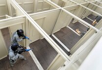 Airmen with the 50th Security Forces Squadron clear the hallway during an active-shooter response live scenario training Aug. 20 at the shoot house. As part of the training, four security forces personnel respond to a threat, enter the facility, eliminate the threat and clear the building. (U.S. Air Force photo/Staff Sgt. Julius Delos Reyes)