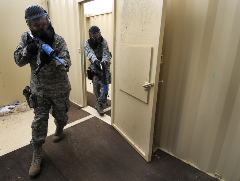 A team of 50th Security Forces Squadron Airmen clears a room in the shoot house during an active-shooter response live scenario training Aug. 20 as part of its annual training program, which includes approximately 20 hours of combined training via classroom, practical applications and live scenarios. Adding realism to the scenarios were the actors playing victims and threats as well as the use of simunitions, a paintball-type weapon. (U.S. Air Force photo/Staff Sgt. Julius Delos Reyes)