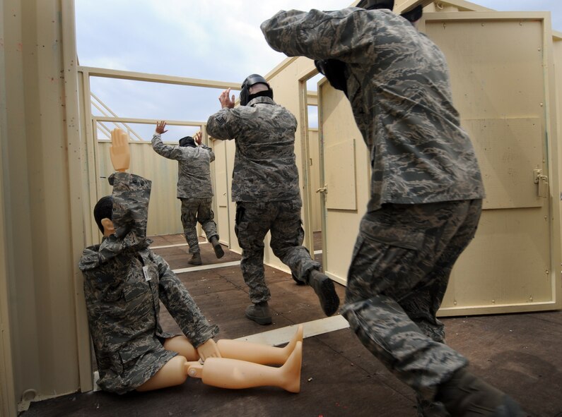 Airmen playing friendlies run through the hallway during an active-shooter response live scenario training Aug. 20 at the shoot house. The 50th Security Forces Squadron conducted the training as part of its annual training program, which includes approximately 20 hours of combined training via classroom, practical applications and live scenarios. (U.S. Air Force photo/Staff Sgt. Julius Delos Reyes)