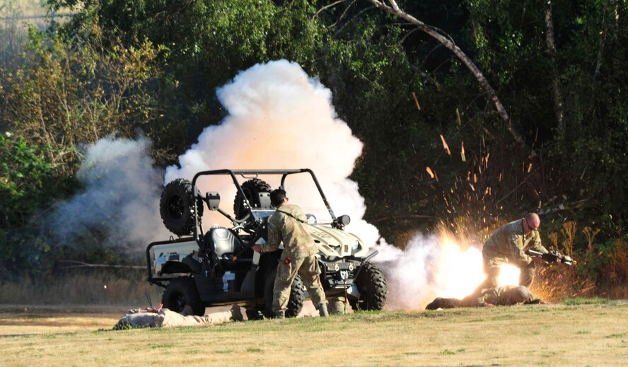 Col. Wyn Elder, 62nd Airlift Wing commander and Chief Master Sgt. Bruce Dixon, 24th Special Operations command chief master sergeant and guest speaker, are taken under attack during a simulated scenario Aug. 17, 2012 during the McChord Field Combat Dining-in at Heritage Hill, Joint Base Lewis-McChord, Wash. More than 600 Airmen attended this year's event. (U.S. Air Force photo/Master Sgt. Todd Wivell)