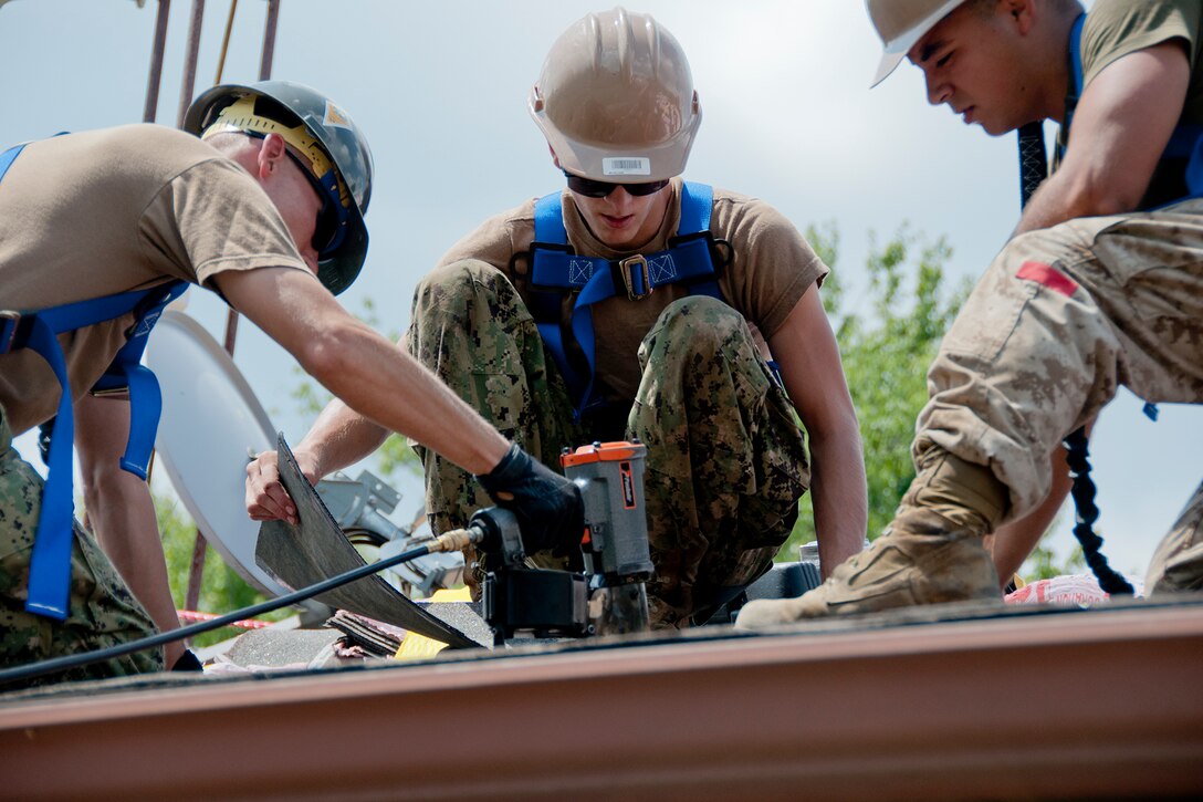 KENSINGTON, Ohio -- U.S. Naval Reserve Petty Offcier 2nd Class Aaron Szalay, a construction mechanic with Navy Mobile Construction
Battalion 26, Detachment 14, CNSW Cody Thompson, also from NMCB 26, Det 14, and U.S. Marine Corps Reserve Lance Cpl. Michael E. Correa, from 4th Landing Support Battalion all based at Youngstown Air Reserve Station, Ohio, work together to complete a construction project Aug. 15, 2012 at Seven Ranges Scout Camp here. Airmen, Marines and Sailors from YARS participated in a two-week joint training exercise at the camp and worked together to improve roads and drainage systems, erect campsites and excavate land for future projects. U.S. Air Force photo by Staff Sgt. Megan Tomkins/Released
