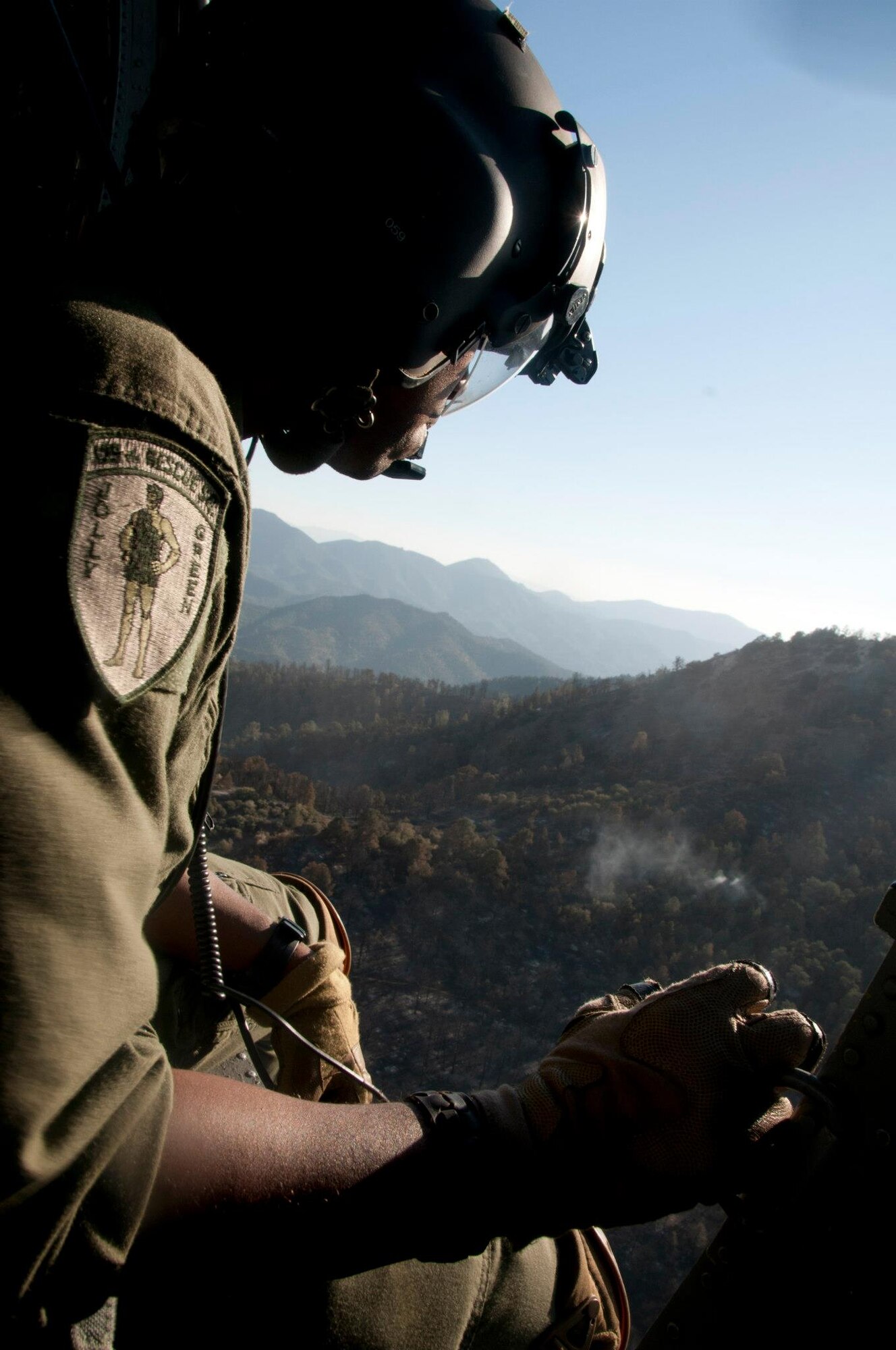 California Air National Guard, Tech. Sgt. Michael Porter, an aerial gunner assigned to the 129th Rescue Squadron, releases water from the bucket attached to an HH-60G Pave Hawk rescue helicopter, while battling the Jawbone Complex Fire in Kern County, Calif., Aug. 15, 2012.. During the support of the Bureau of Land Management, Kern County fire, and Cal Fire; the 129th Rescue Wing has performed more than 120 bucket drops. (Air National Guard photo by Master Sgt. Julie Avey/Released)