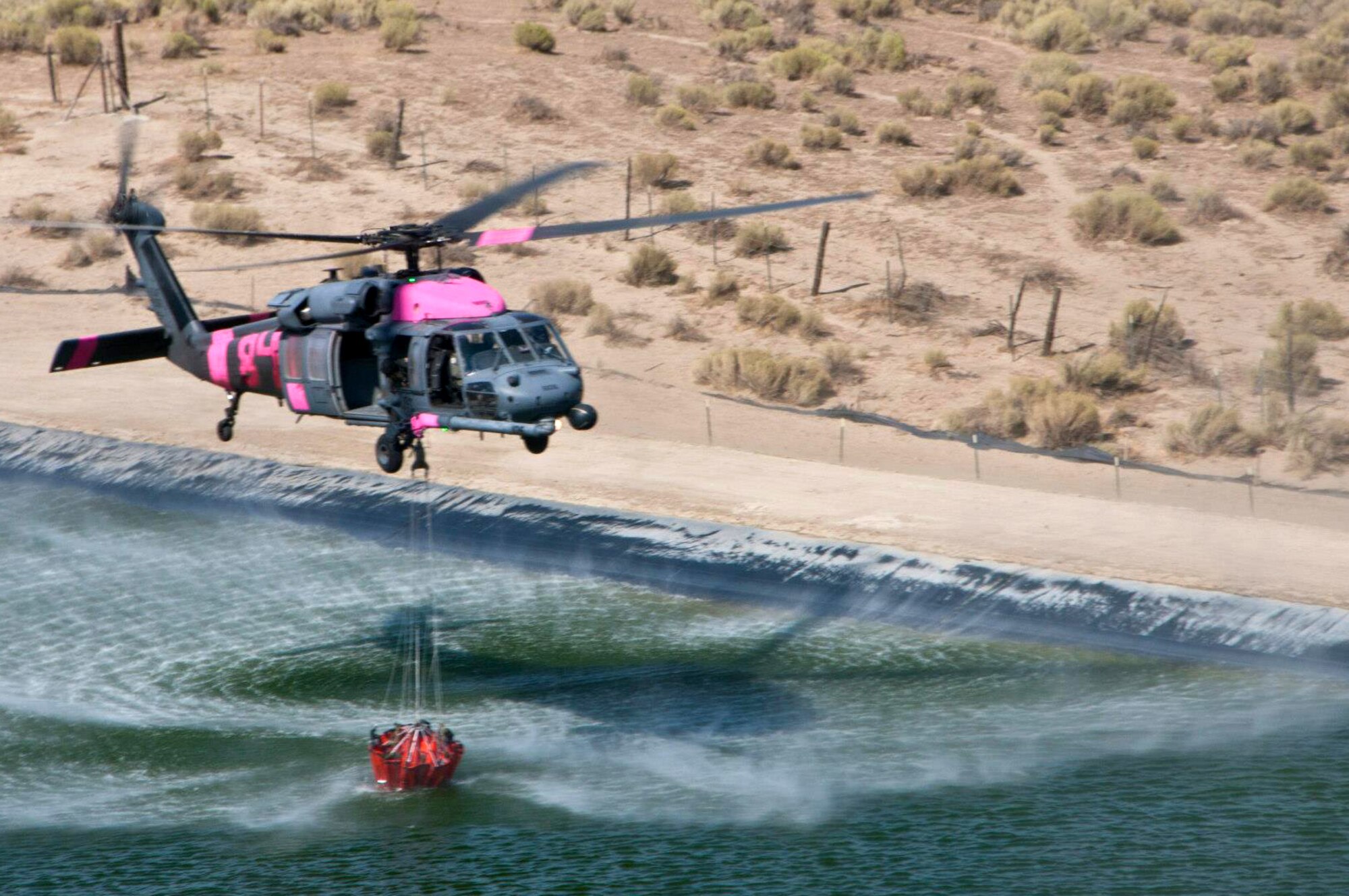 California Air National Guard HH-60G Pave Hawk rescue helicopter and air crew, assigned to the 129th Rescue Wing collect water in preparation for bucket drops over the Jawbone Complex Fire in Kern County, Calif., Aug. 15, 2012. During the support of the Bureau of Land Management, Kern County fire, and Cal Fire; the 129th Rescue Wing has performed more than 120 bucket drops. (Air National Guard photo by Master Sgt. Julie Avey/Released)