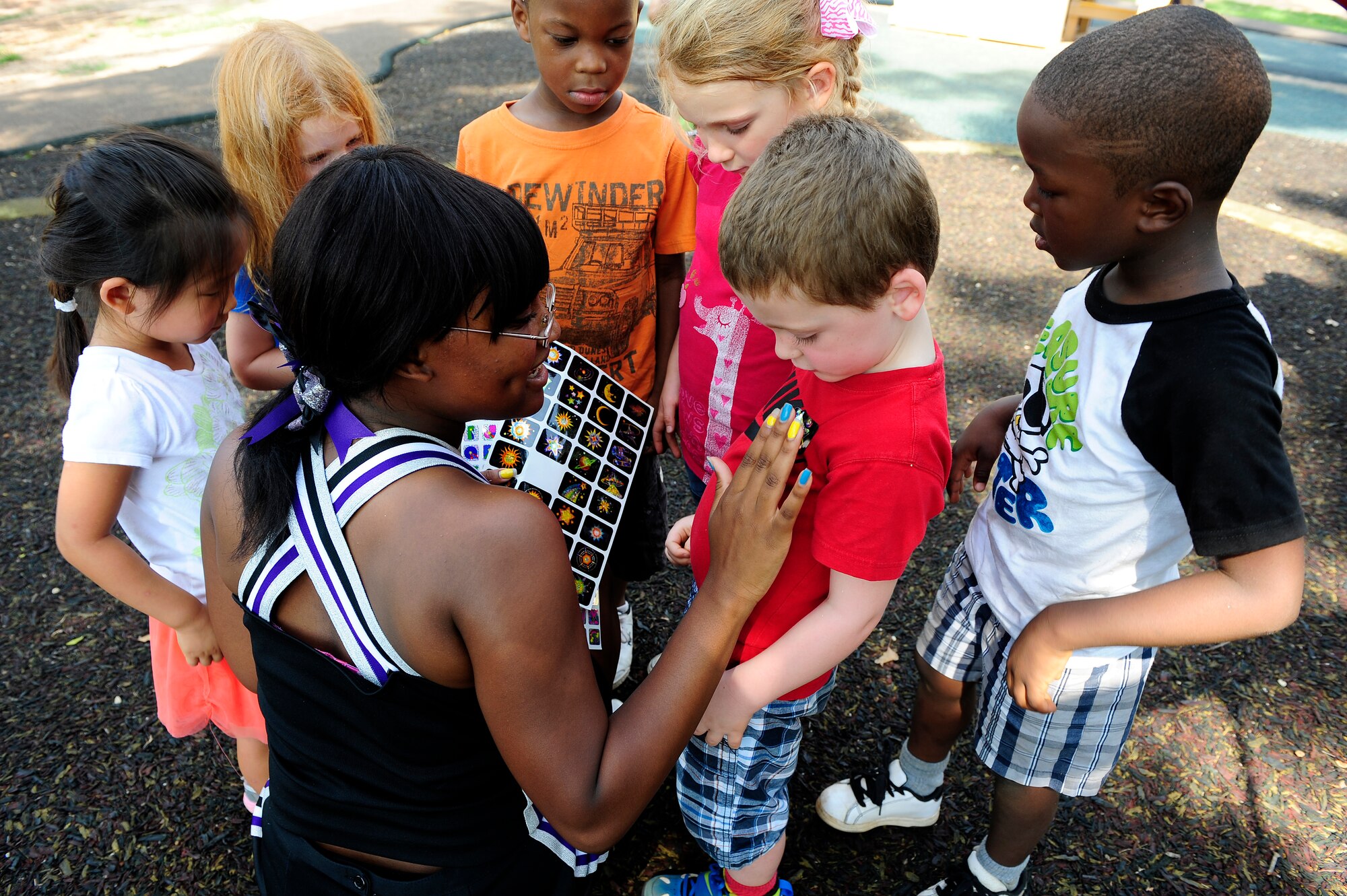 Crestwood High school varsity cheerleading captian MicKayla Ketter hands out stickers to the children at the Childcare Development Center at Shaw Air Force Base, S.C., Aug. 15, 2012. Ketter and members of her high school’s cheer squad came to teach children about sportsmanship and teamwork. (U.S. Air Force photo by Airman 1st Class Hunter Brady /Released)