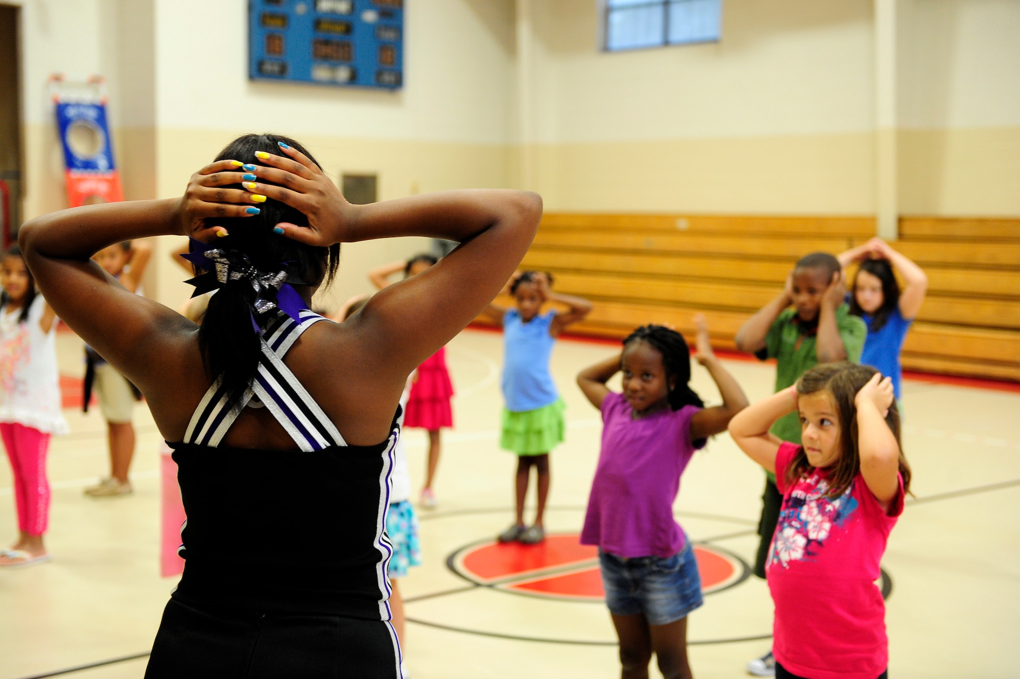 Crestwood High school varsity cheerleading captian, MicKayla Ketter, teaches a few cheers to children from the Childcare Development Center at Shaw Air Force Base, S.C., Aug. 15, 2012. Ketter and members of her high school’s cheer squad came to teach children about sportsmanship and teamwork. (U.S. Air Force photo by Airman 1st Class Hunter Brady /Released)