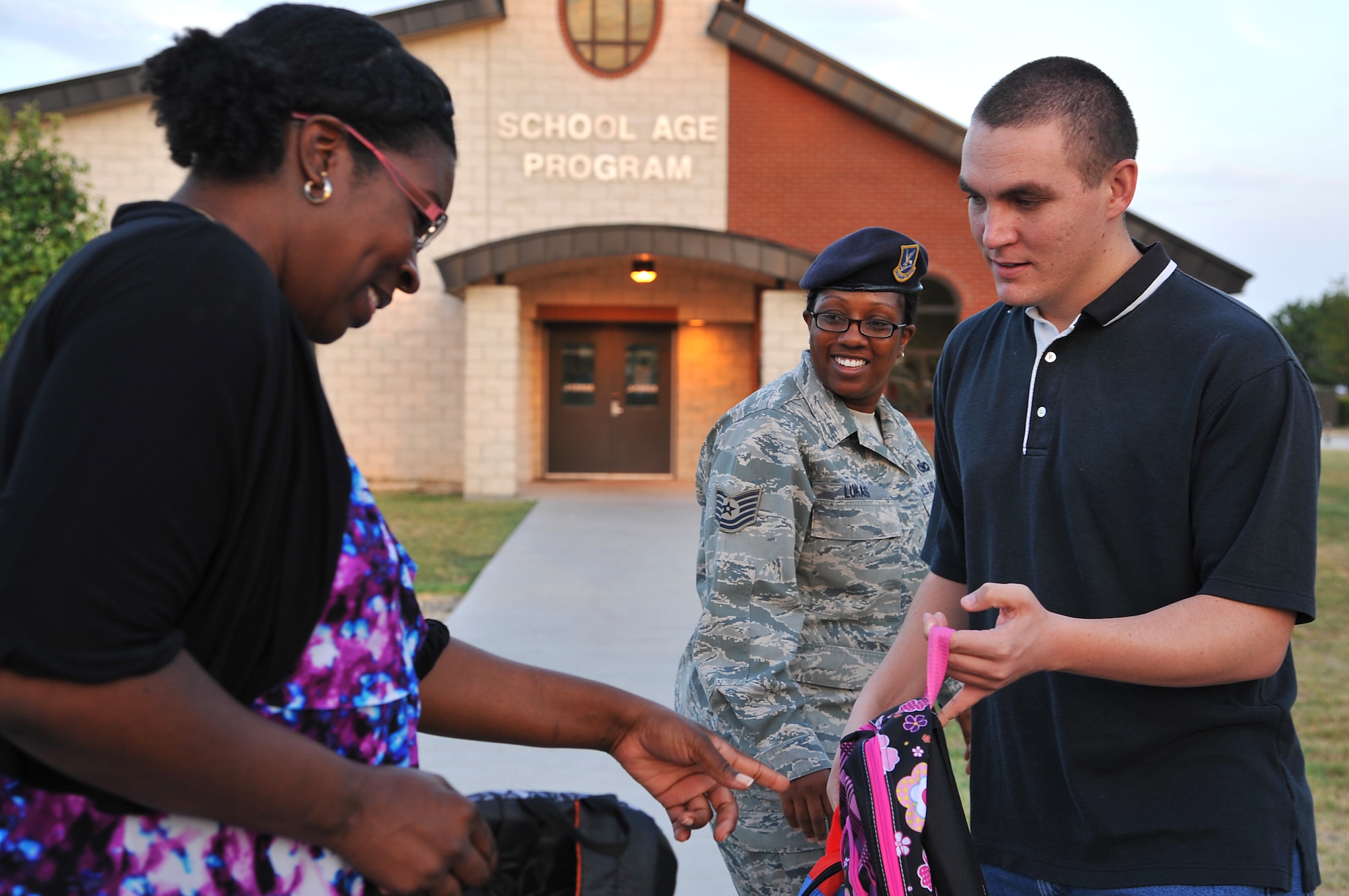 GOODFELLOW AIR FORCE BASE, Texas-- Staff Sgt. Sean Curtin, 17th Security Forces Squadron, hands a backpack to Karla Hall, 17th Medical Operations Squadron, at the School Age Program building Aug. 17. The 17th SFS raised money to donate backpacks and school supplies to children before the start of school. (U.S. Air Force photo/ Airman 1st Class Michael Smith)