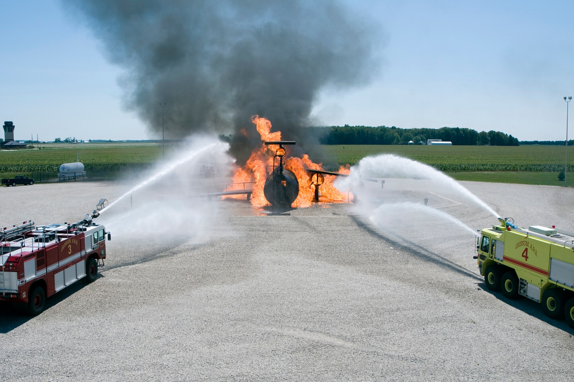 GRISSOM AIR RESERVE BASE, Ind. -- Grissom firefighters operating two firefighting trucks extinguish the flames coming from a mock airframe here Aug. 1. The GFD demonstrated their training for members of the media who were visiting the base. (U.S. Air Force photo/Senior Airman Andrew McLaughlin)
