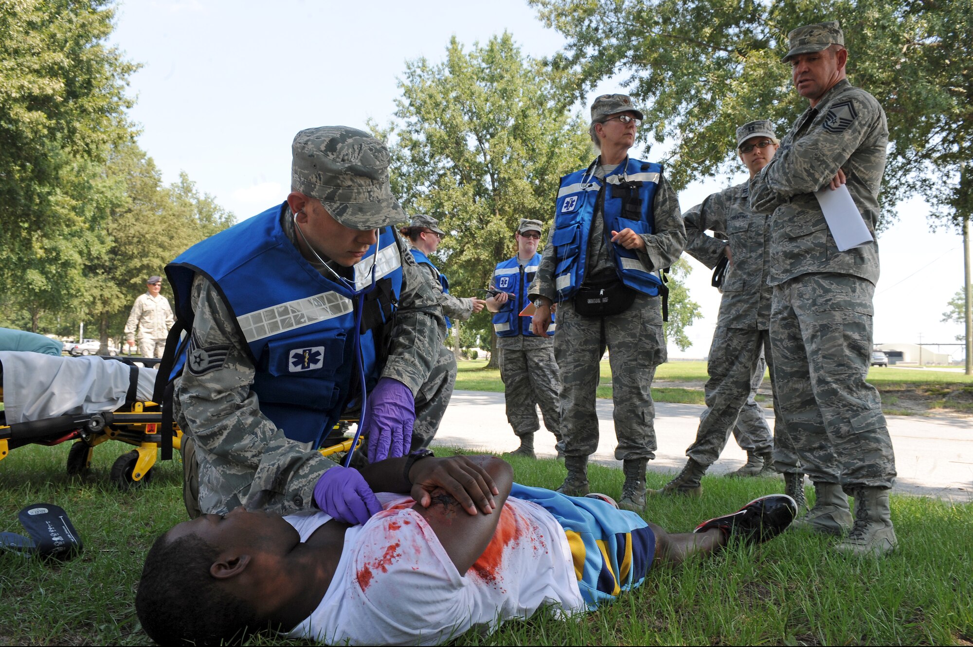 Exercise evaluation team members watch as medical treatment is performed during an exercise on Seymour Johnson Air Force Base, N.C., Aug. 14, 2012. EET members evaluated participants on how well they reacted to a real-life scenario. (U.S. Air Force photo/Airman 1st Class John Nieves Camacho/Released)