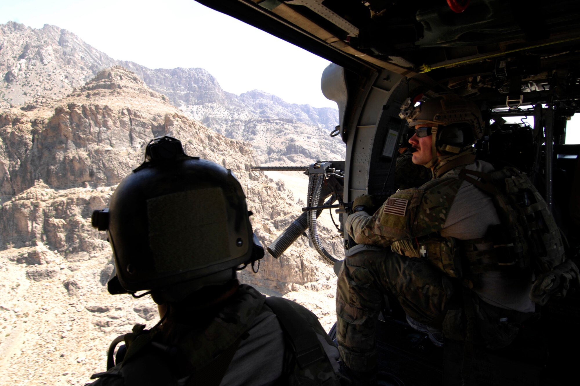 A pararescue jumper and a combat rescue officer assigned to the 83rd Expeditionary Rescue Squadron peer out the side door of a U.S. Air Force HH-60 Pave Hawk helicopter as the Hindu Kush mountain range comes into view during a training mission at Bagram Airfield, Afghanistan, Aug. 18, 2012. Brig. Gen. Joseph Guastella, 455th Air Expeditionary Wing commander, took part in a nearly two hour training mission with PJs and CROs of the 83 ERQS, also known as the “Pedros,” to see firsthand how they contribute to the war on terrorism here in Afghanistan. Guastella expressed his appreciation for their efforts and for their part in continuing to making the mission a success. (U.S. Air Force photo/SSgt Jeff Nevison)