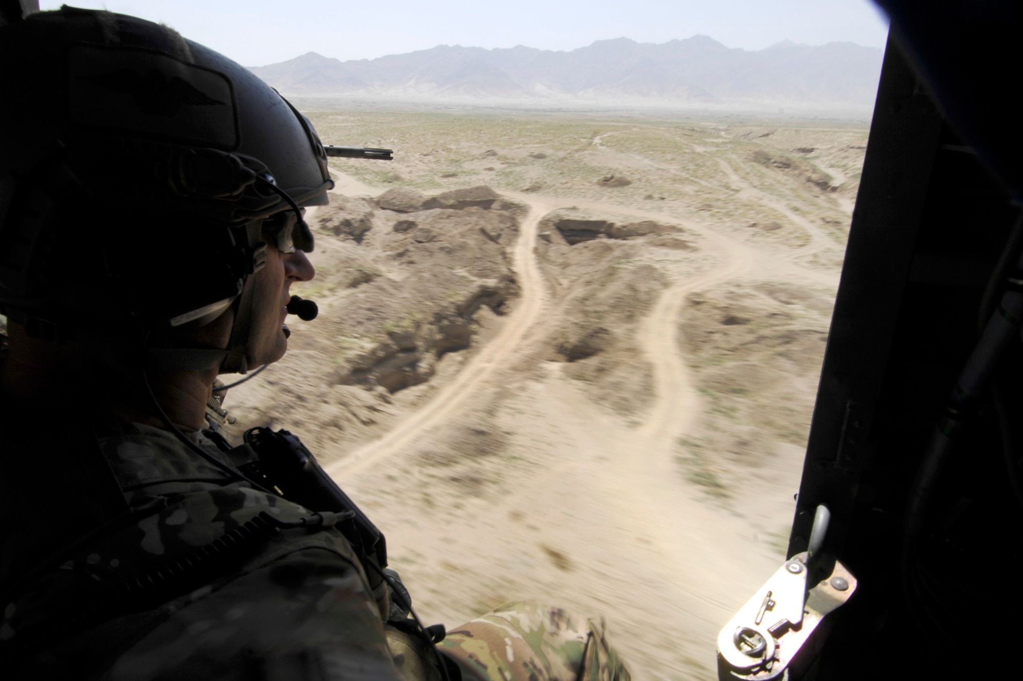 Brig. Gen. Joseph Guastella, 455th Air Expeditionary Wing commander, peers out the side door of a U.S. Air Force HH-60 Pave Hawk helicopter during a training mission with pararescue jumpers and combat rescue officers assigned to the 83rd Expeditionary Rescue Squadron at Bagram Airfield, Afghanistan, Aug. 18, 2012. Guastella took part in a nearly two hour training mission with PJs and CROs of the 83 ERQS, also known as the “Pedros,” to see firsthand how they contribute to the war on terrorism here in Afghanistan. Guastella expressed his appreciation for their efforts and for their part in continuing to making the mission a success. (U.S. Air Force photo/SSgt Jeff Nevison)