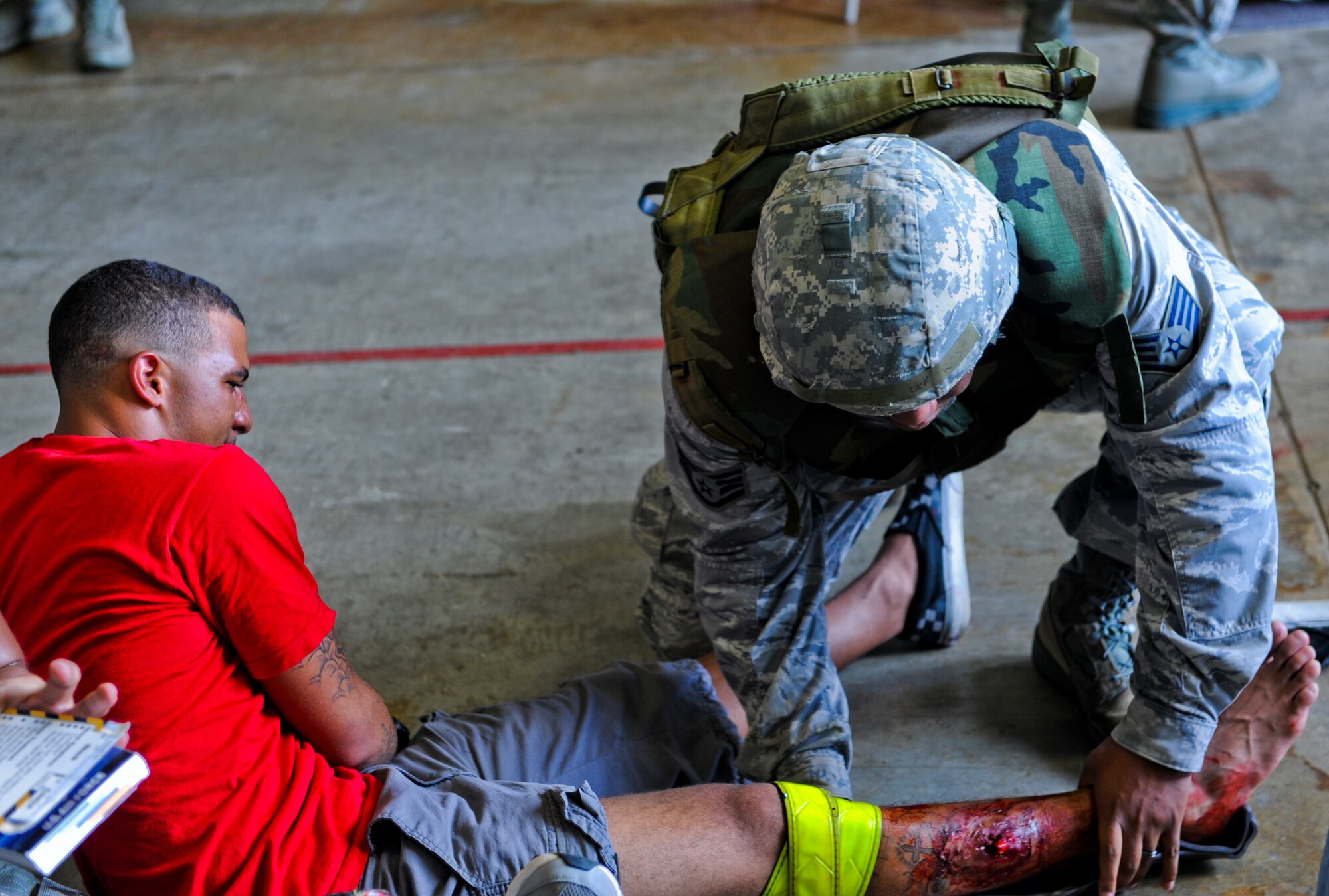 U.S. Air Force Staff Sgt. Robert Rose, 33rd Rescue Squadron independent duty medical technician, performs self-aid buddy care on Airman Michael Leiba, 18th Security Forces response force member, during local operational readiness exercise Beverly High 12-5 on Kadena Air Base, Japan, Aug. 21, 2012. This week-long exercise tests the Airmen on their ability to survive and operate in a multitude of scenarios in order to prepare them for real world contingencies. (U.S. Air Force photo/Airman 1st Class Justin Veazie)