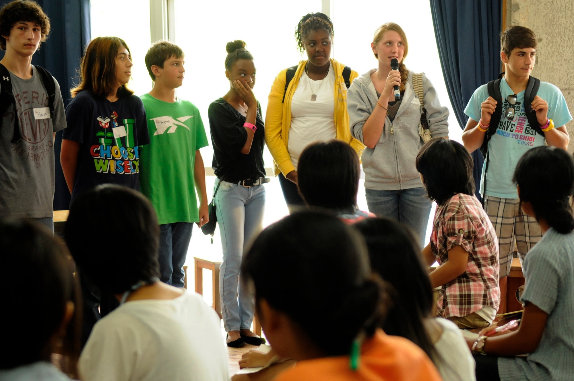 Taylor Carter, president of the Kadena Teen Center's Keystone Club, greets the teens of the Okinawa Prefectural Board of Education English Summer Camp 2012 teens during a youth exchange event in Nanjo City, Japan. The camp is a way to give the Okinawan students confidence in their English speaking skills. (U.S. Air Force photo/ Airman 1st Class Tara A. Williamson)