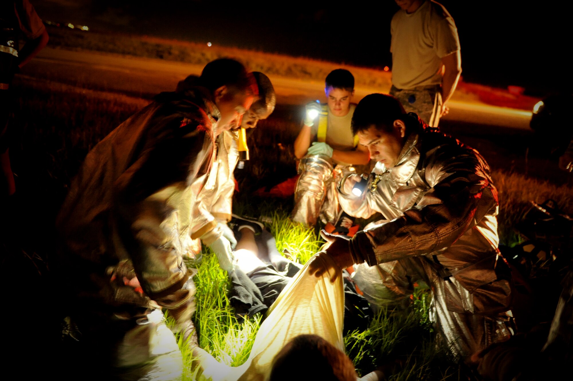 U.S. Air Force Staff Sgt. Noah Paxton, 18th Civil Engineer Squadron fire crew chief, lifts up the shirt of U.S. Air Force Airman 1st Class Marcanthony Black, 18th Logistics Readiness Squadron vehicle operation dispatcher, to check for additional wounds during a training exercise on Kadena Air Base, Japan, Aug. 21, 2012. The training scenario was part of local operational readiness exercise Beverly High 12-5, which allows Kadena to test its Airmen and see how they would react in real world contingencies. (U.S. Air Force photo/Airman 1st Class Brooke P. Beers)