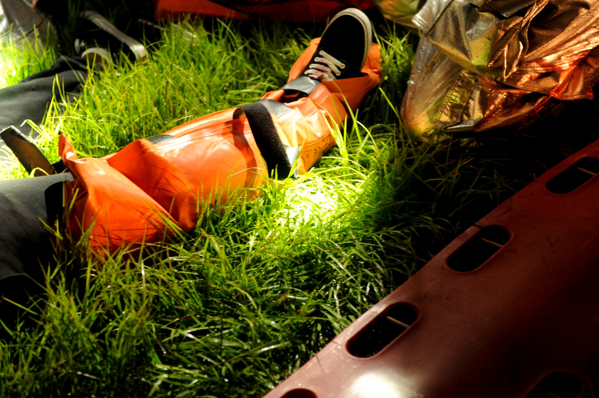 U.S. Air Force firefighters from the 18th Civil Engineer Squadron splint Airman 1st Class Marcanthony Black's, 18th Logistics Readiness Squadron vehicle operation dispatcher, leg during a training exercise on Kadena Air Base, Japan, Aug. 21, 2012. For the exercise, Black received moulage (stage makeup) on his leg to make it look like he had been run over by a vehicle to add more realism to the training. (U.S. Air Force photo/Airman 1st Class Brooke P. Beers)