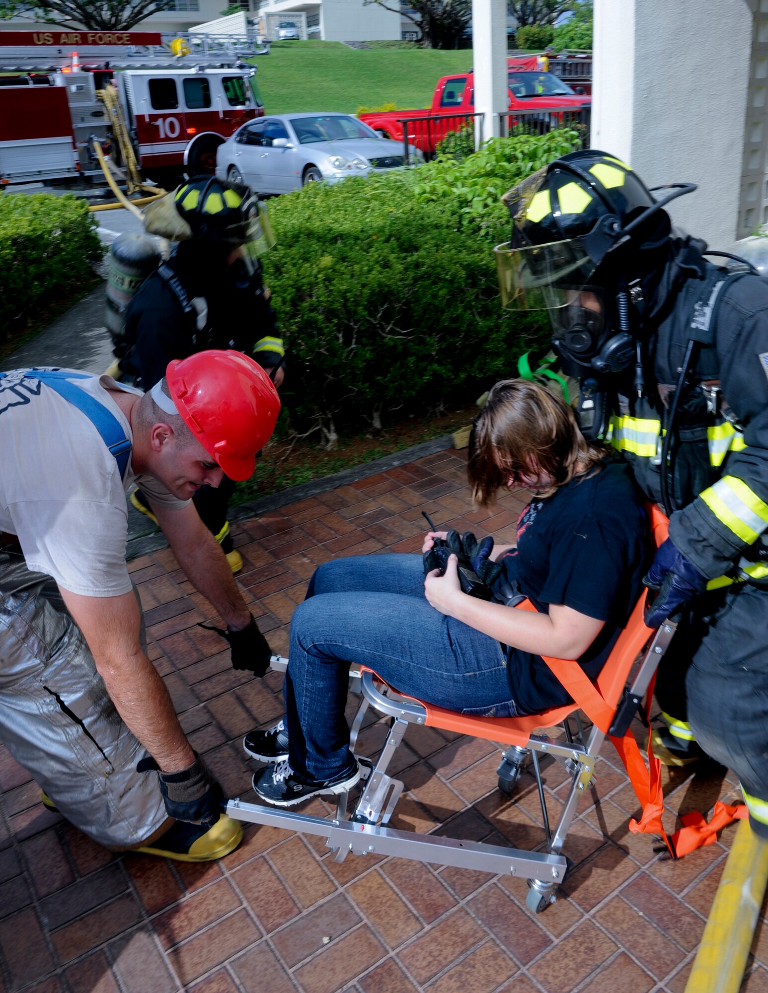 Firefighters prepare to lift a simulated victim to transport her to a triage area during Beverly High 12-5, a local operational readiness exercise on Kadena Air Base, Japan, Aug. 21, 2012. Emergency responder scenarios are critical to provide training for firefighters to prepare them for real world contingencies. (U.S. Air Force photo/Airman 1st Class Justin Veazie)