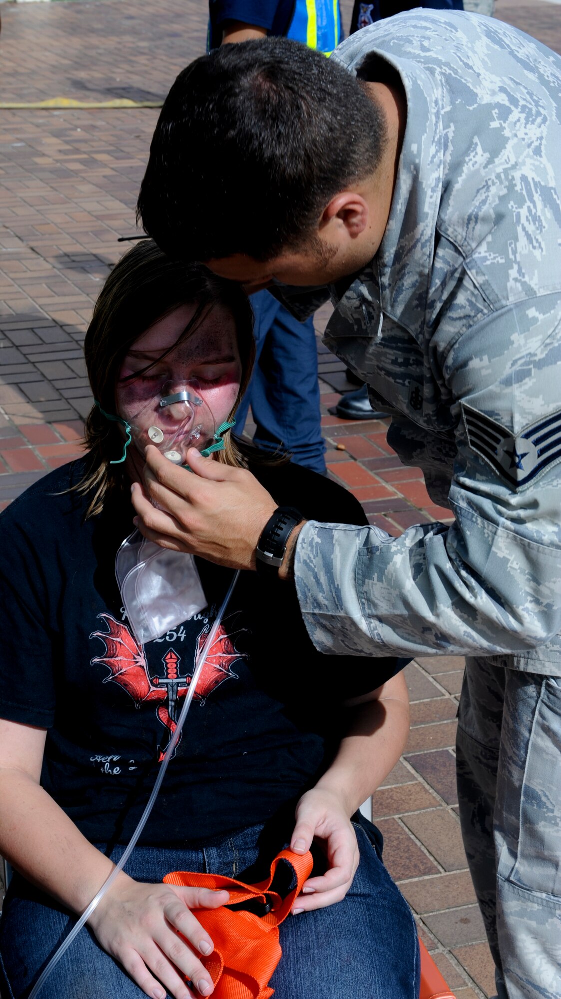 U.S. Air Force Staff Sgt. Warren Williamson, 18th Medical Operations Squadron medic, gives Airman 1st Class Jenell Fenwick, 733rd Air Mobility Squadron air freight technician and simulated victim, oxygen after being pulled out of the simulated burning building on Kadena Air Base, Japan, Aug. 21, 2012. The week-long local operational readiness exercise tests Kadena Airmen on their ability to survive and operate in a multitude of scenarios in order to prepare them for real world contingencies. (U.S. Air Force photo/Airman 1st Class Justin Veazie) 