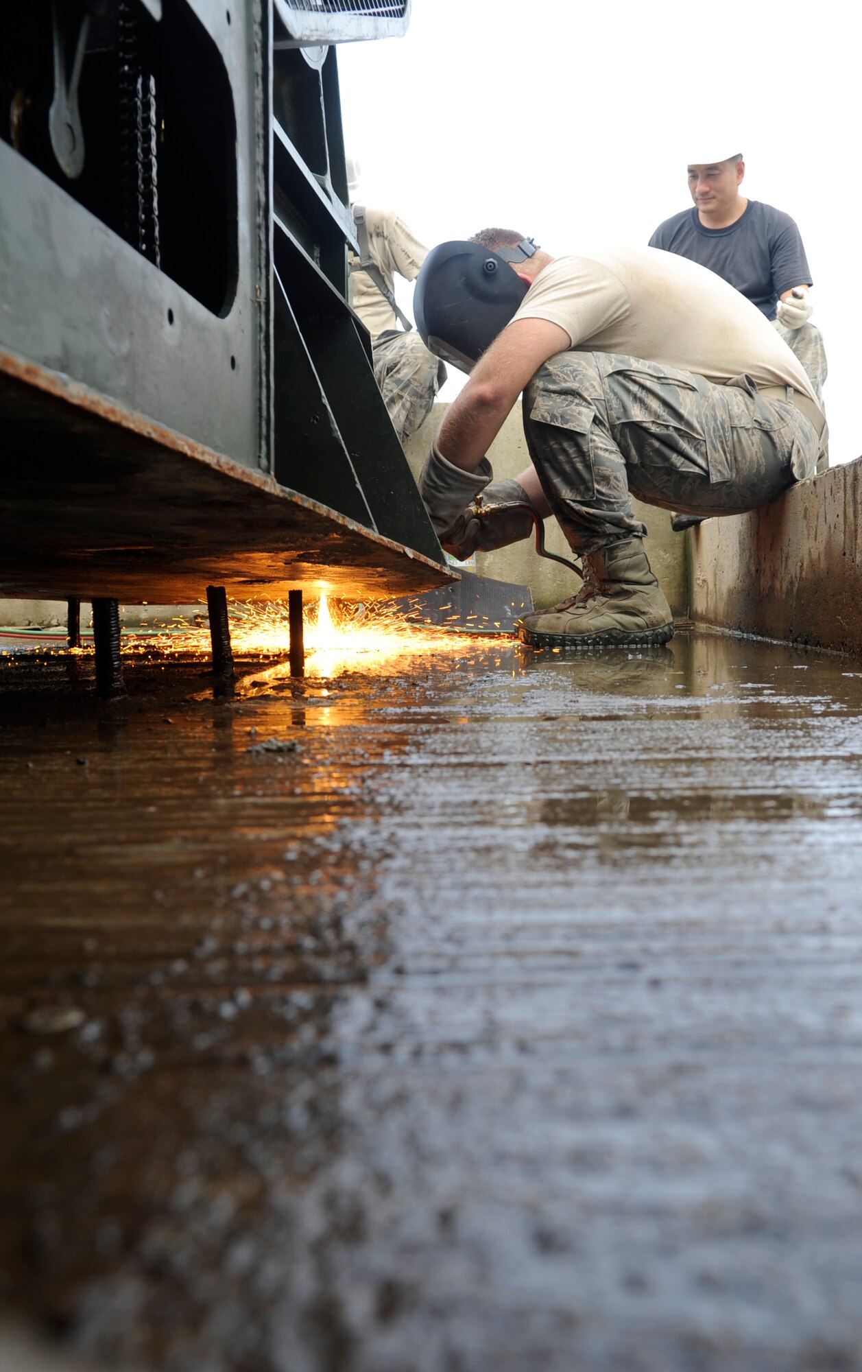 An aircraft arresting system is moved into place on pegs by Airmen from the 8th Civil Engineer Squadron at Kunsan Air Base, Republic of Korea, Aug. 18, 2012. The heavy equipment, power production and structures shops worked together to make the emergency braking system once again functional. (U.S. Air Force photo/Senior Airman Brigitte N. Brantley)