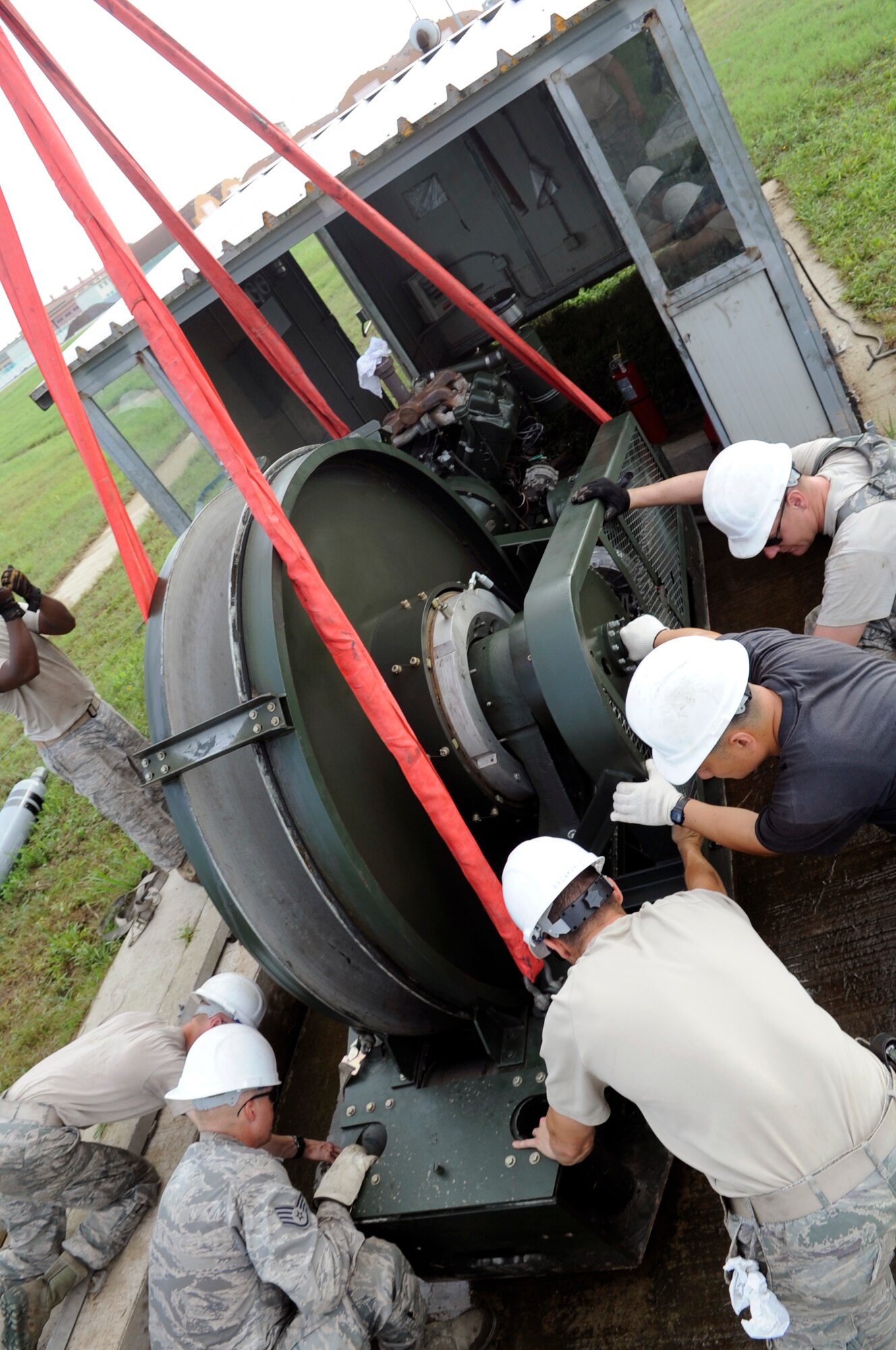 Airmen from the 8th Civil Engineer Squadron heavy equipment, power production and structures shops move an aircraft arresting system into place at Kunsan Air Base, Republic of Korea, Aug. 18, 2012. The emergency braking system replaced a system that was damaged after heavy rains last week. (U.S. Air Force photo/Senior Airman Brigitte N. Brantley)