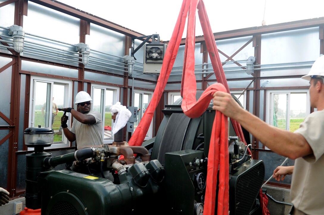 Staff Sgt. Robert Davis, 8th Civil Engineer Squadron heavy equipment operator, left, signals to a crane operator while they move an aircraft arresting system at Kunsan Air Base, Republic of Korea, Aug. 18, 2012. After nearly a foot of rainfall here last week, the braking systems were under water. (U.S. Air Force photo/Senior Airman Brigitte N. Brantley)