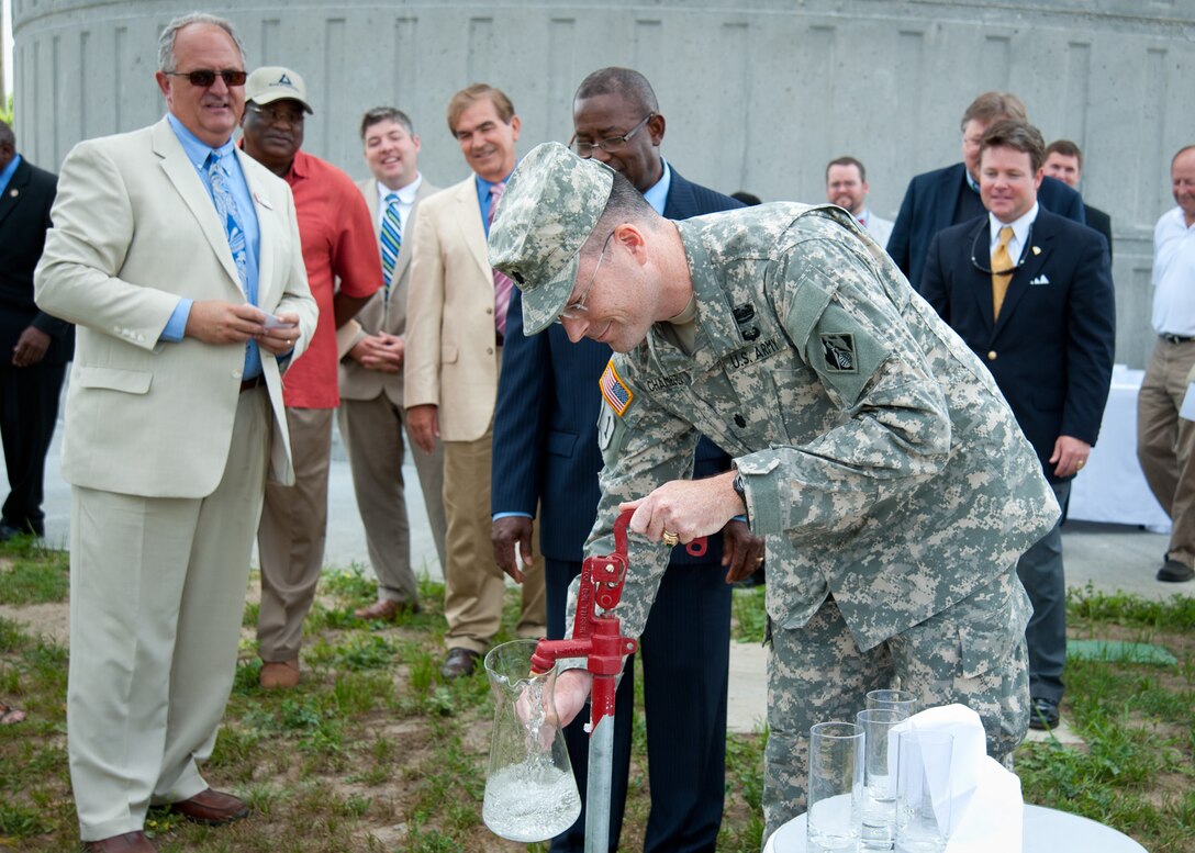 Lt. Col. Ed Chamberlayne pours the first pitcher of water from the new water tower.