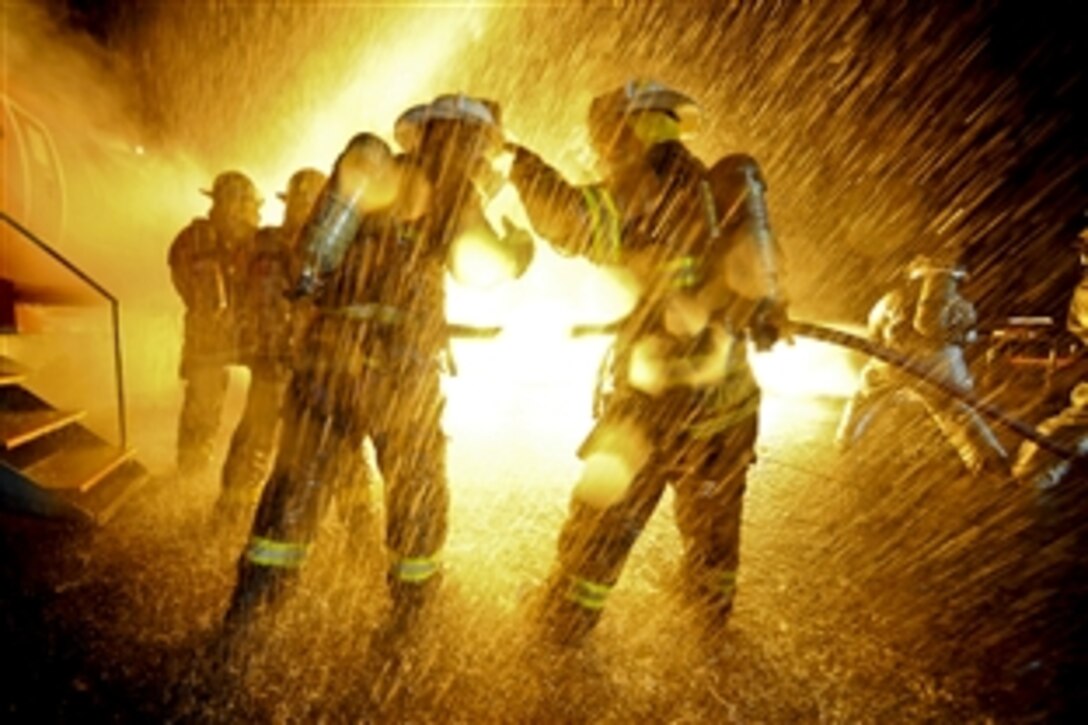 Air Force firefighters train with civilian firefighters from five locations to remove simulated victims from a burning aircraft on Francis S. Gabreski Air National Guard Base in Westhampton, New York, Aug. 15, 2012. The airmen are assigned to the 106th Civil Engineering Squadron. Kellogg University provided the mock aircraft, which burned with propane at an estimated 1,200 degrees. 