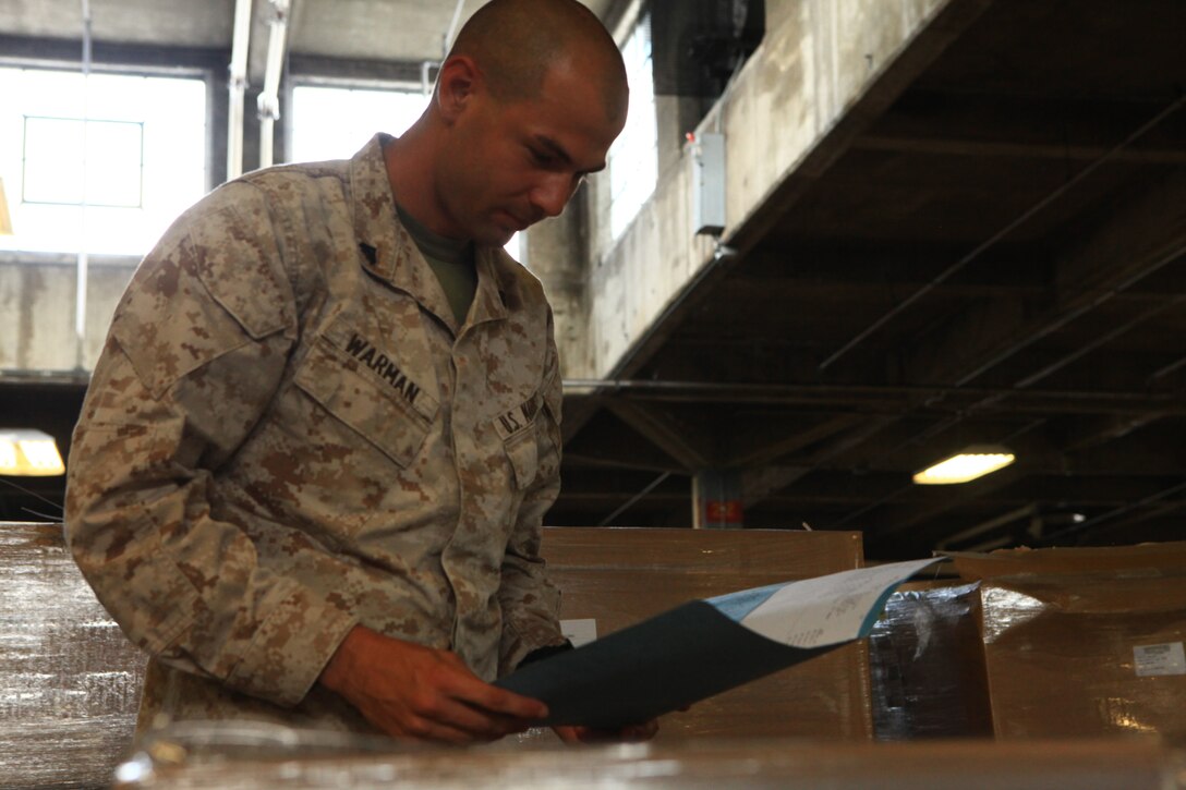 Cpl. Samuel L. Warman, a distribution management specialist with Supply Company, 2nd Supply Battalion, 2nd Marine Logistics Group, reviews paperwork for gear coming though the supply warehouse aboard Camp Lejeune, N.C., Aug. 16, 2012. The Military Affairs Committee for the Greater Jacksonville Chamber of Commerce recognized Warman for his outstanding professionalism and contributions to his unit and the community. (Photo by Lance Cpl. Paul Peterson)