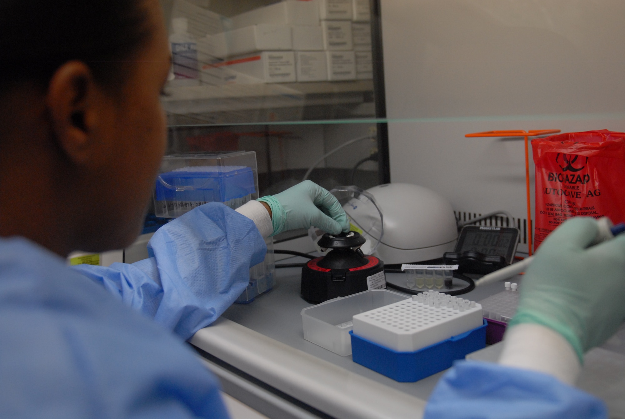 U.S. Air Force Tech. Sgt. Alexia Wells, 18th Medical Group NCO in charge of lab operations, simulates placing a specimen in a centrifuge machine for DNA analysis during local operational readiness exercise Beverly High 12-5 on Kadena Air Base, Japan, Aug. 22, 2012. LOREs are conducted to test the base's ability to not only defend Japan, but also maintain peace and stability in the Pacific region. (U.S. Air Force photo/Airman 1st Class Hailey R. Davis)