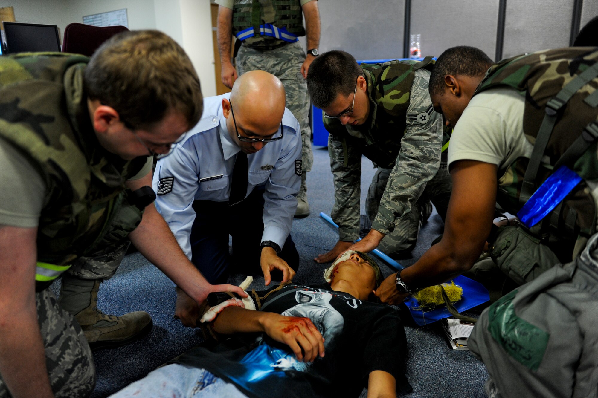 Members of the 18th Communications Squadron perform self-aid and buddy care on simulated casualty during local operational readiness exercise Beverly high 12-5 on Kadena Air Base, Japan, Aug. 22, 2012. The week-long exercise is designed to test Kadena's Airmen on their ability to survive and operate in a multitude of scenarios in order to prepare them for real world contingencies. (U.S. Air Force photo/Airman 1st Class Justin Veazie)