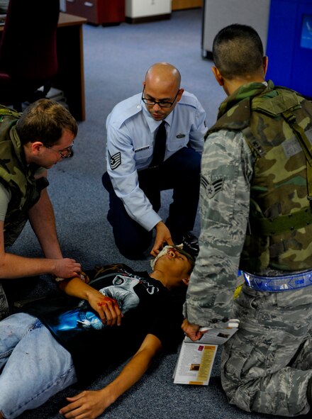 U.S. Air Force Tech. Sgt. Emmanuel Garcia, Senior Airman Simon Tan and Airman 1st Class Jason Doyle, all 18th Communications Squadron client systems technicians, perform self-aid and buddy care on a simulated victim during local operational readiness exercise Beverly High 12-5 on Kadena Air Base, Japan, Aug. 22, 2012. LOREs give Airmen a good opportunity to practice readiness skills and prepare for real world contingencies in a controlled environment. (U.S. Air Force photo/Airman 1st Class Justin Veazie)