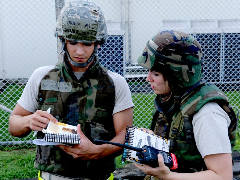 U.S. Air Force Airmen 1st Class Jody Jones and Jean-Luc Hurier, 18th Communications Squadron client system technicians, reference to their AFPAM 10-100 Airman's Manual on the post attack reconnaissance sweep during local operational readiness exercise Beverly High 12-5 on Kadena Air Base, Japan, Aug. 22, 2012. LOREs give Airmen a good opportunity to practice readiness skills and prepare for real world contingencies. (U.S. Air Force photo/Airman 1st Class Justin Veazie)