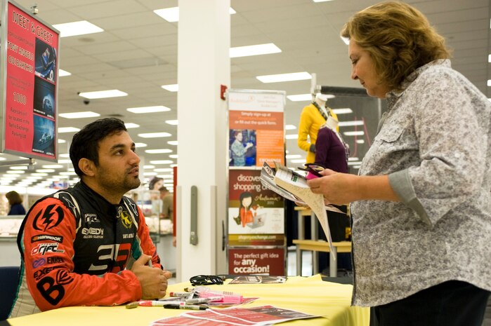 Tony Angelo, professional formula drift driver, signs an autograph for a fan during a meet and greet at the Nellis Base Exchange Aug. 22, 2012, at Nellis Air Force Base, Nev. Angelo will be competing in a drift competition at the Las Vegas Motor Speedway Aug. 24 and 25. (U.S. Air Force photo by Airman 1st Class Christopher Tam)