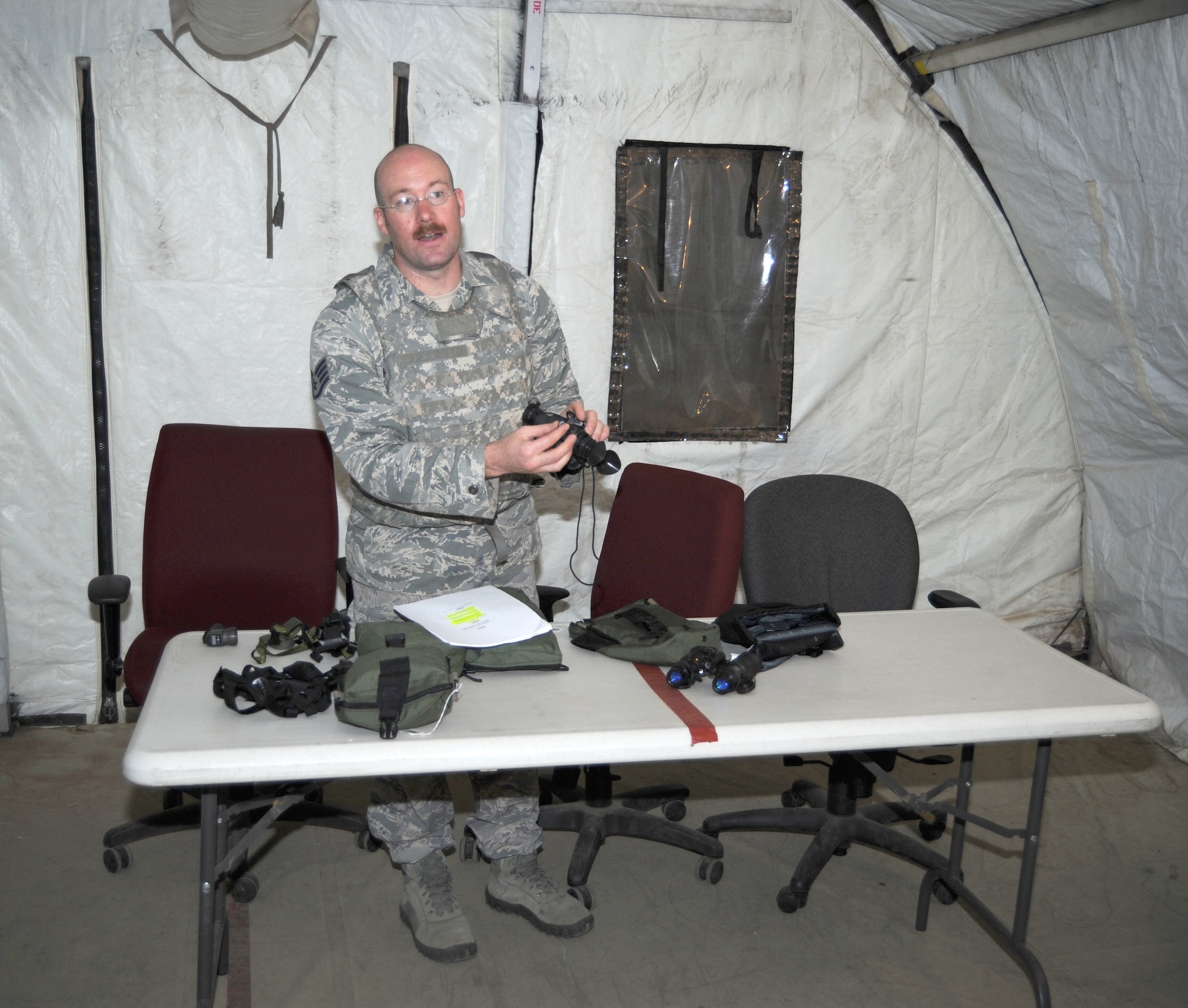 Staff Sgt. Nathan Melazzo, 355th Civil Engineer Squadron explosive ordinance disposal, teaches Airmen on the different versions of night vision goggles and how to use them during a night training exercise at Davis-Monthan Air Force Base, Ariz., August 16. With NVGs on the user can clearly see in the dark, but their depth perception is affected. (U.S. Air Force photo by Airman 1st Class Michael Washburn/Released)