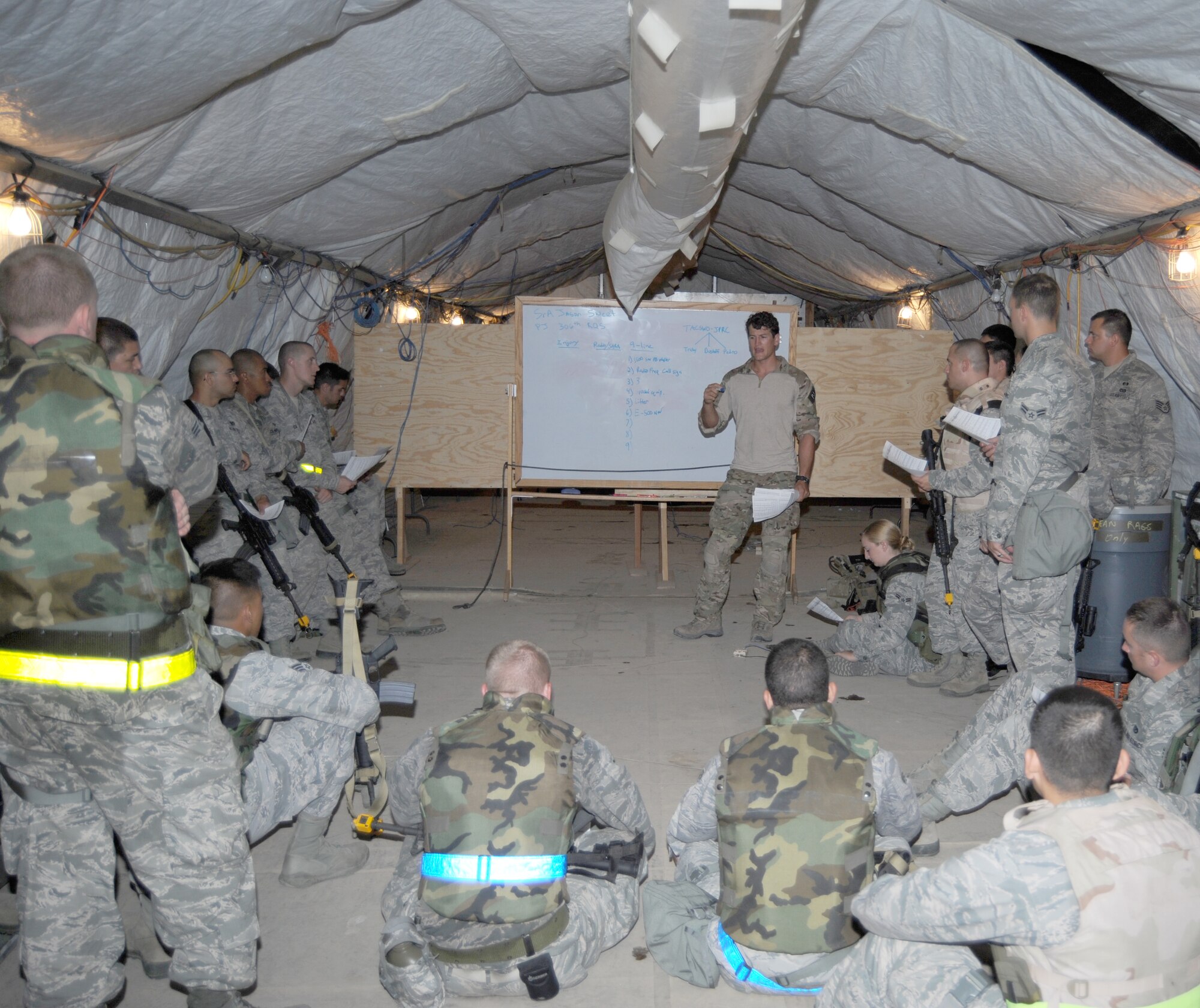 Senior Airman Jason Sweet, 306th Rescue Squadron pararescueman, briefs Airmen from the 355th Civil Engineer Squadron on the use of 9-line during a night training exercise at Davis-Monthan Air Force Base, Ariz., August 16. Nine-line is used to call in urgent evacuation for casualties from the battlefield. (U.S. Air Force photo by Airman 1st Class Michael Washburn/Released)